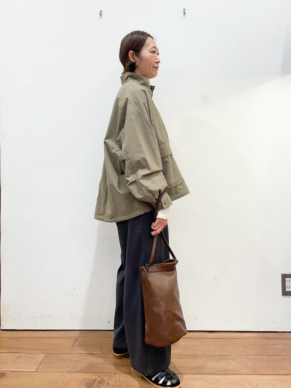 グリーン系のブルゾン、ホワイト系のTシャツ/カットソー、グレー系のその他パンツを着用したレディースの春コーディネートの3枚目の写真