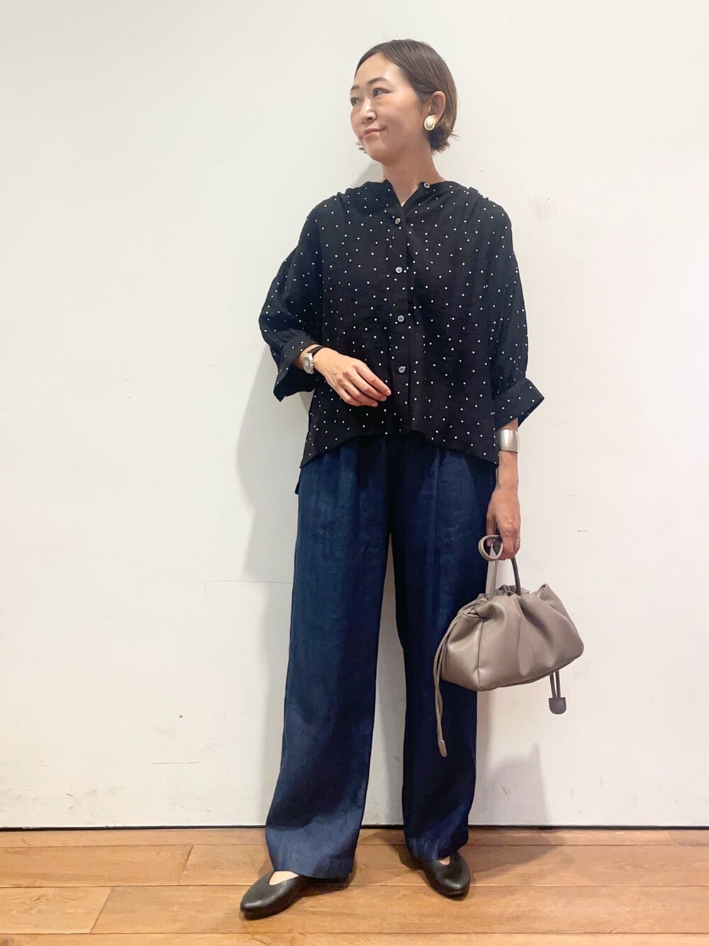 ブラック系のシャツ/ブラウス、ブルー系のデニムパンツ、ベージュ系のショルダーバッグを着用したレディースの夏コーディネートの2枚目の写真