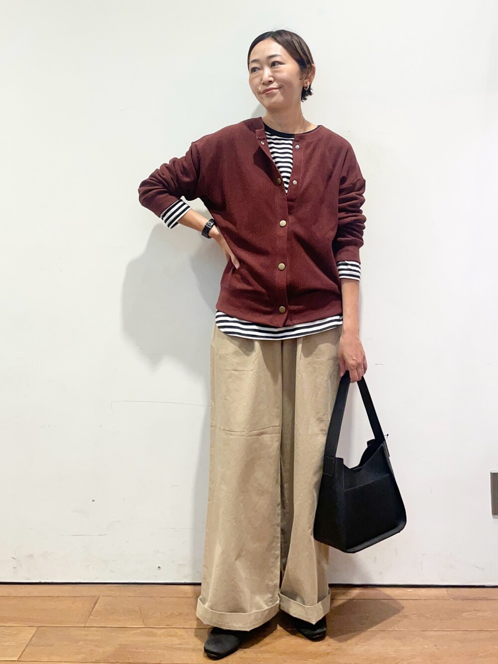 レッド系のカーディガン/ボレロ、ホワイト系のTシャツ/カットソー、ブラック系のハンドバッグを着用したレディースの秋コーディネートの4枚目の写真