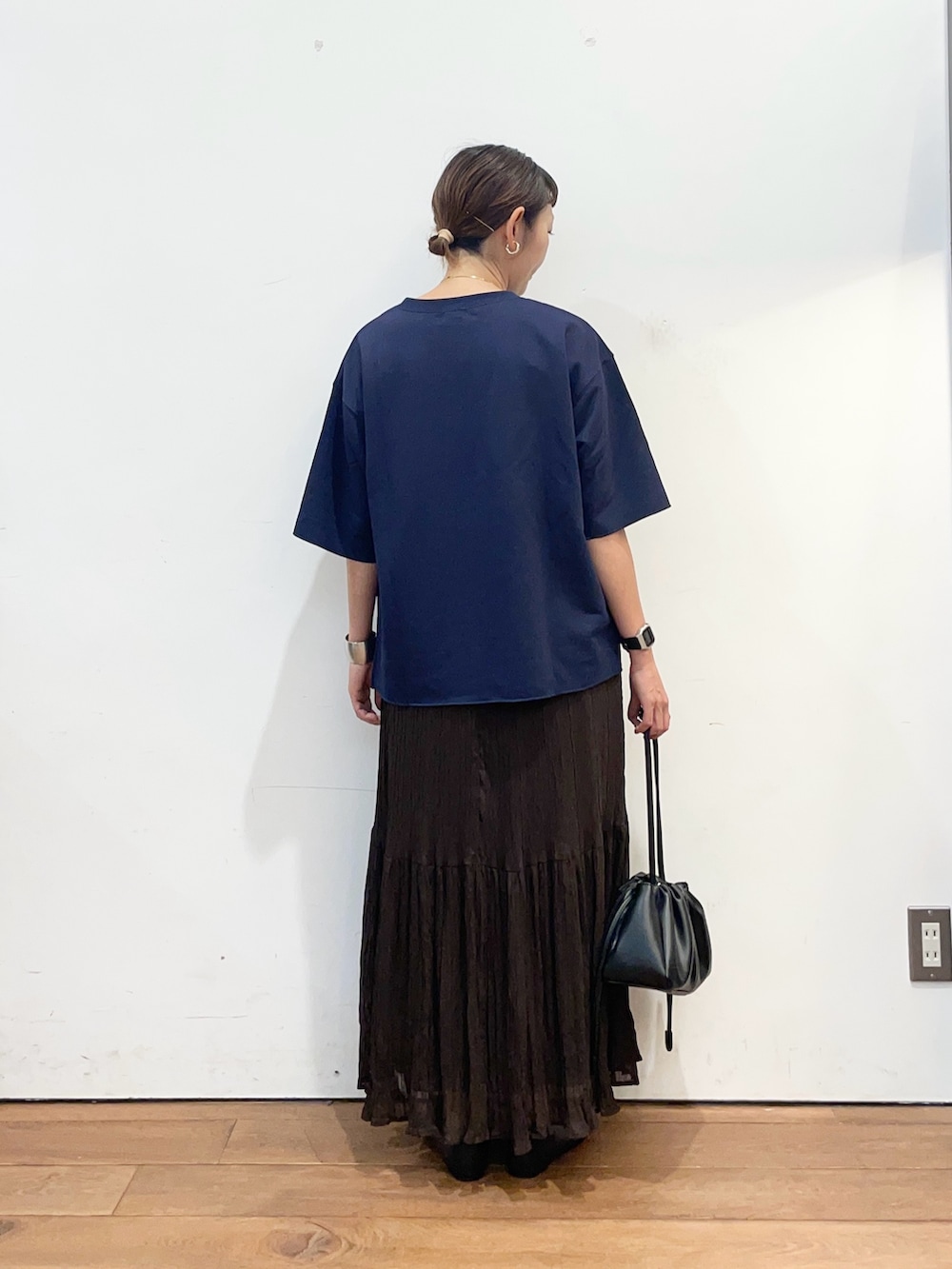 ブルー系のTシャツ/カットソー、ブラウン系のスカート、ブラック系のショルダーバッグを着用したレディースの秋コーディネートの4枚目の写真
