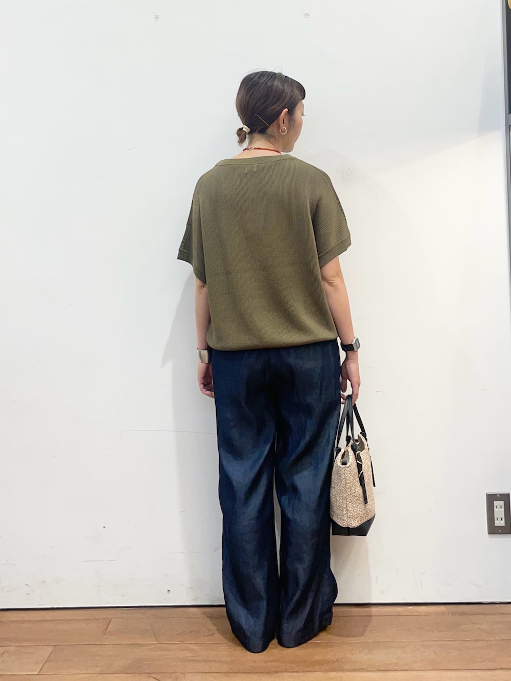 グリーン系のニット/セーター、ブルー系のデニムパンツ、ブラック系のサンダルを着用したレディースの夏コーディネートの4枚目の写真
