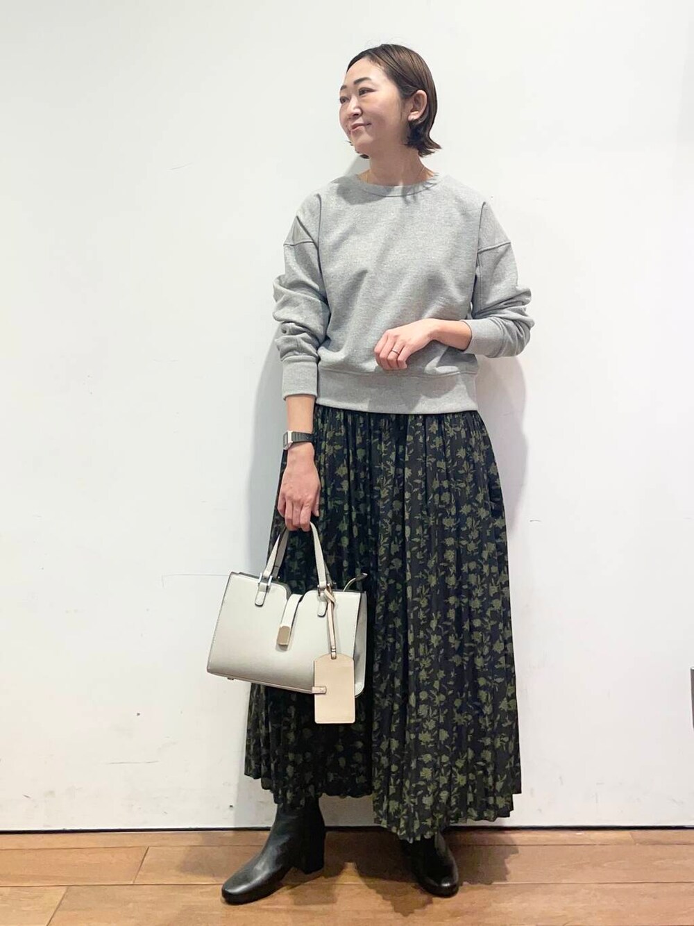 ブラック系のブーツ、グレー系のTシャツ/カットソー、グリーン系のスカートを着用したレディースの冬コーディネートの2枚目の写真