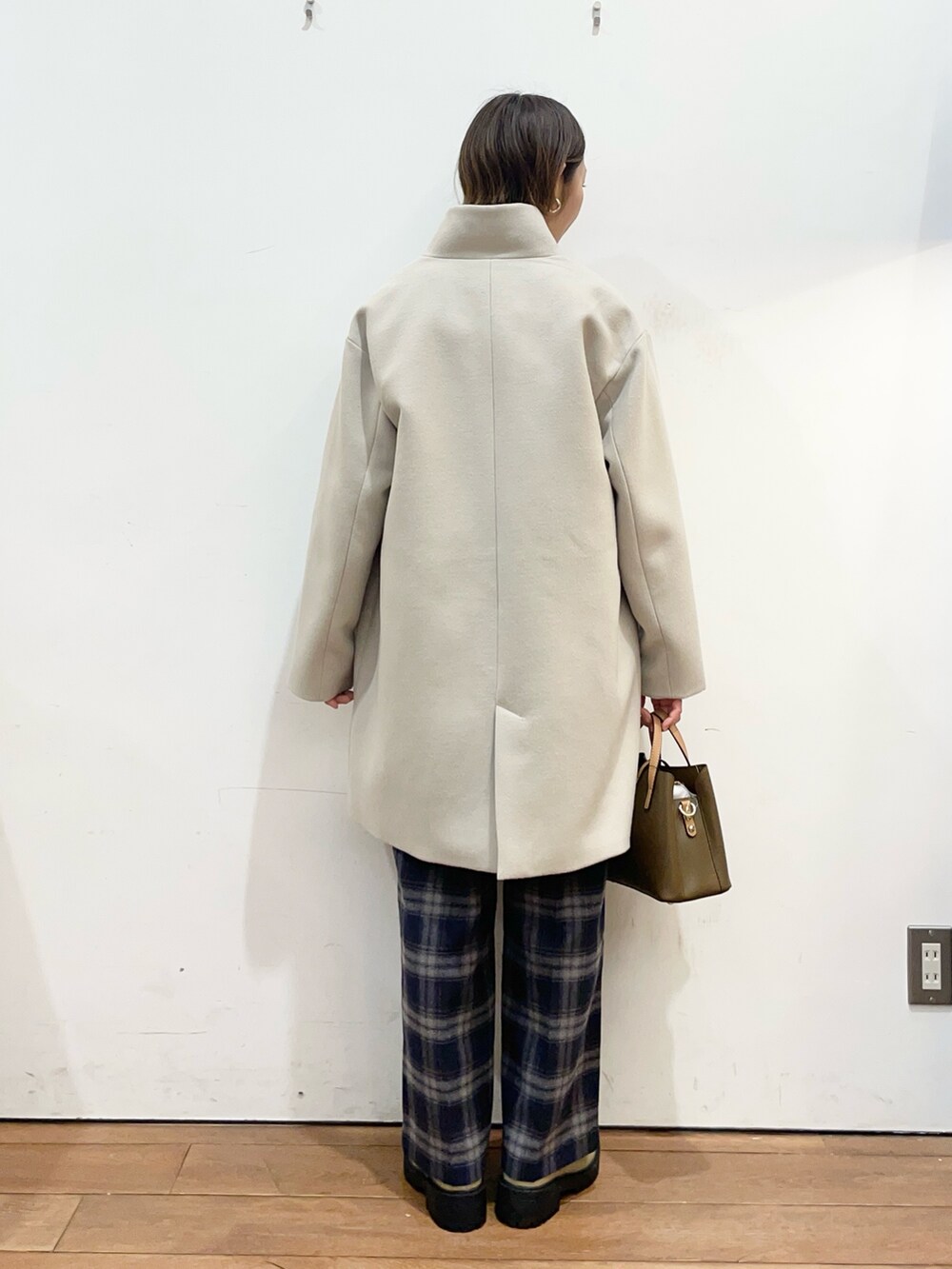 ベージュ系のその他アウター、ブルー系のニット/セーター、ブラウン系のハンドバッグを着用したレディースの冬コーディネートの4枚目の写真