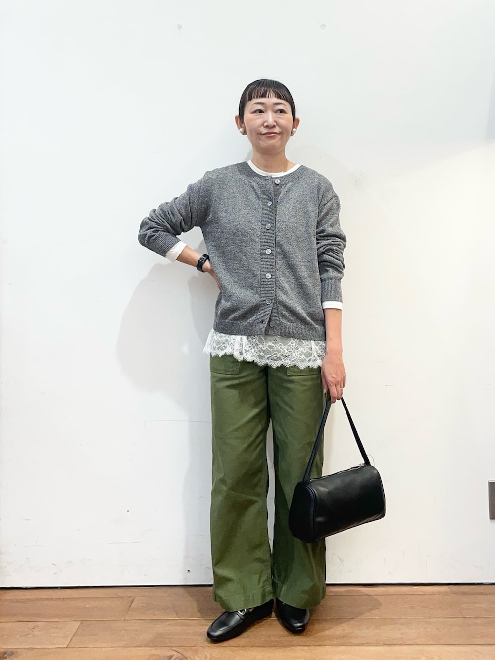 ホワイト系のTシャツ/カットソー、グリーン系のその他パンツ、グレー系のカーディガン/ボレロを着用したレディースの秋コーディネートの2枚目の写真