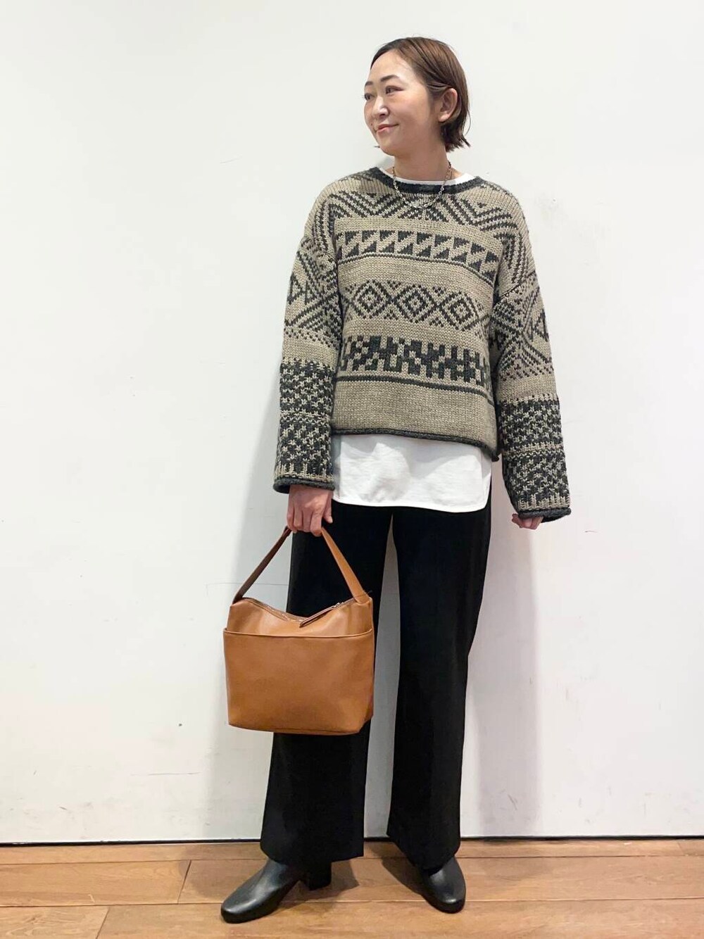 ブラック系のブーツ、イエロー系のショルダーバッグ、ホワイト系のTシャツ/カットソーを着用したレディースの冬コーディネートの3枚目の写真