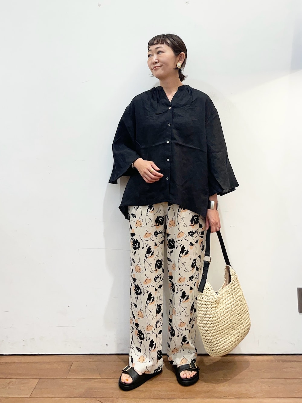 ブラック系のシャツ/ブラウス、ベージュ系のトートバッグ、ブラック系のサンダルを着用したレディースの夏コーディネートの3枚目の写真