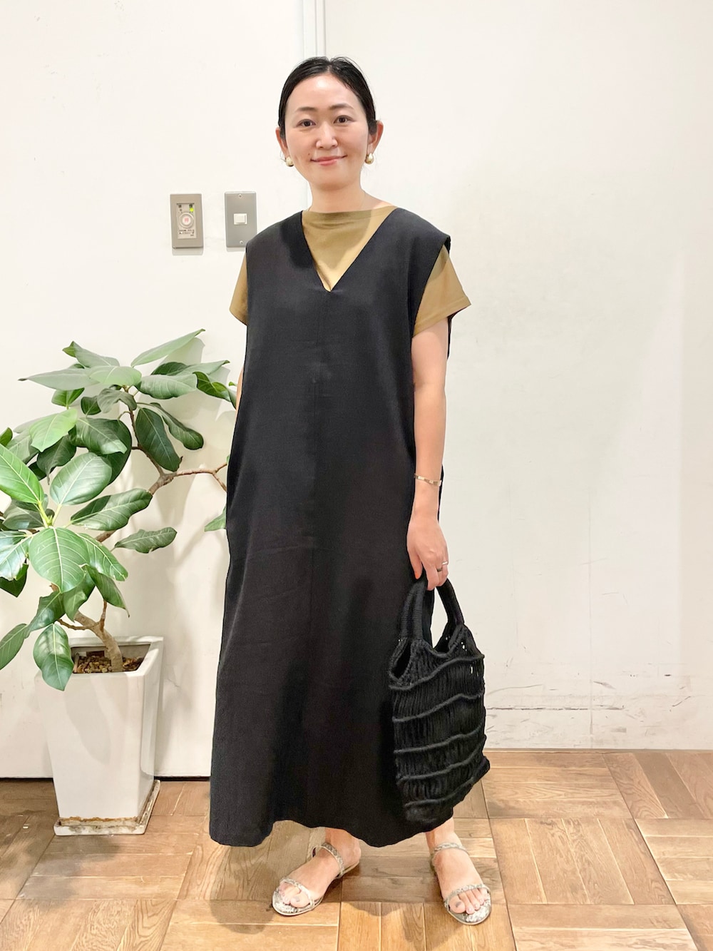 ブラック系のワンピース、ブラウン系のTシャツ/カットソー、グレー系のサンダルを着用したレディースの夏コーディネートの2枚目の写真