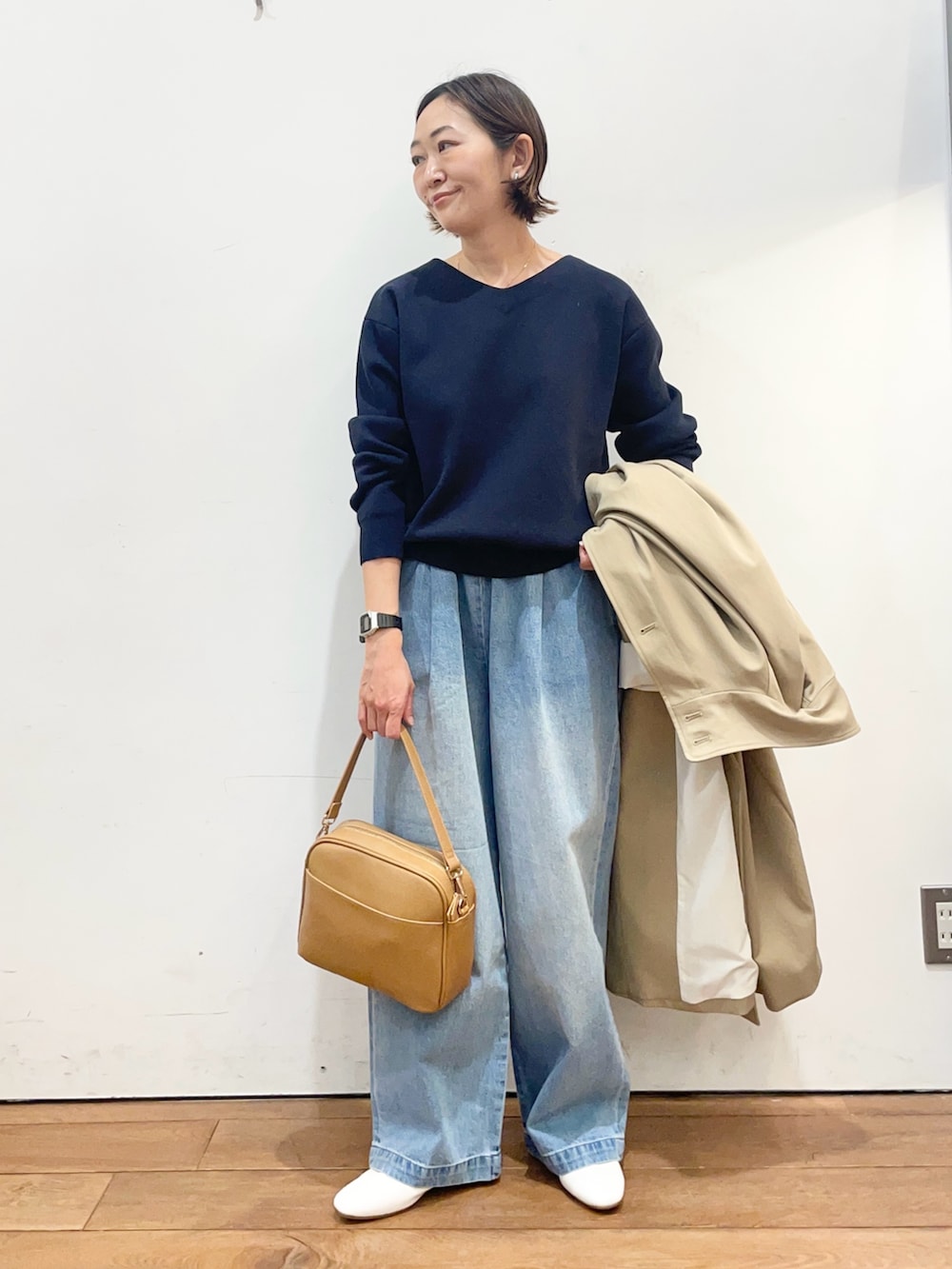 ベージュ系のその他アウター、ブルー系のニット/セーター、ブルー系のデニムパンツを着用したレディースの冬コーディネートの6枚目の写真