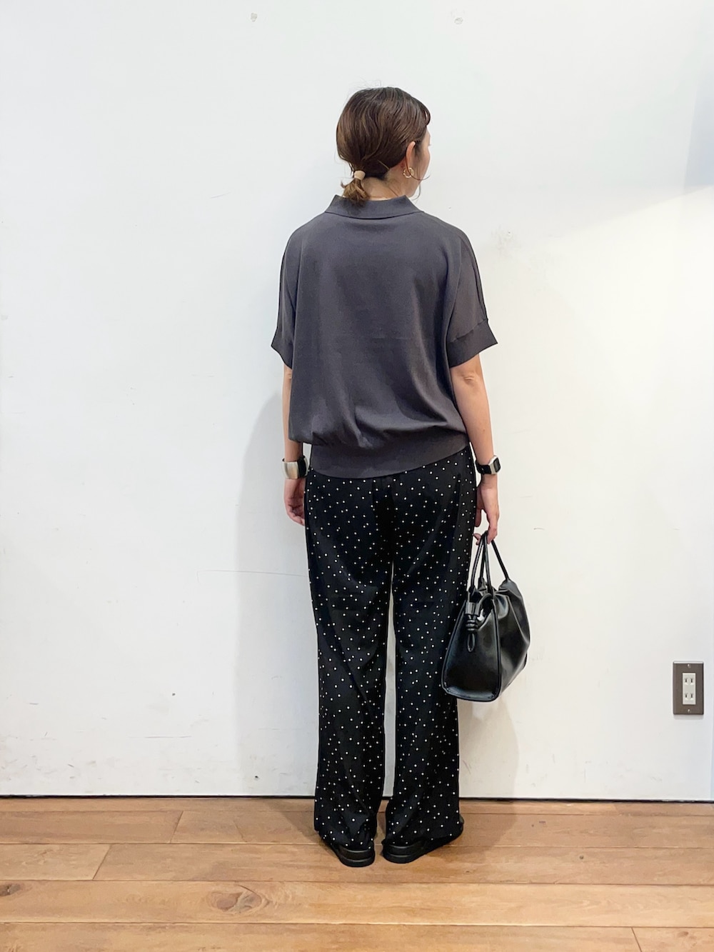 グレー系のニット/セーター、ブラック系のトートバッグ、ブラック系のサンダルを着用したレディースの夏コーディネートの5枚目の写真