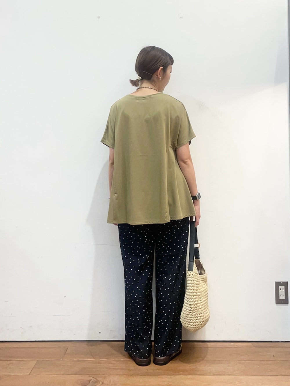 グリーン系のTシャツ/カットソー、ベージュ系のトートバッグ、ベージュ系のサンダルを着用したレディースの夏コーディネートの4枚目の写真