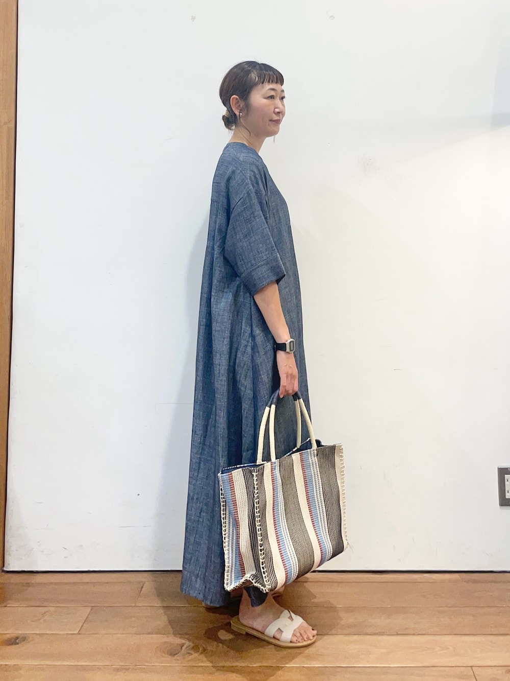 ブルー系のワンピース、ブルー系のトートバッグ、ホワイト系のサンダルを着用したレディースの夏コーディネートの3枚目の写真