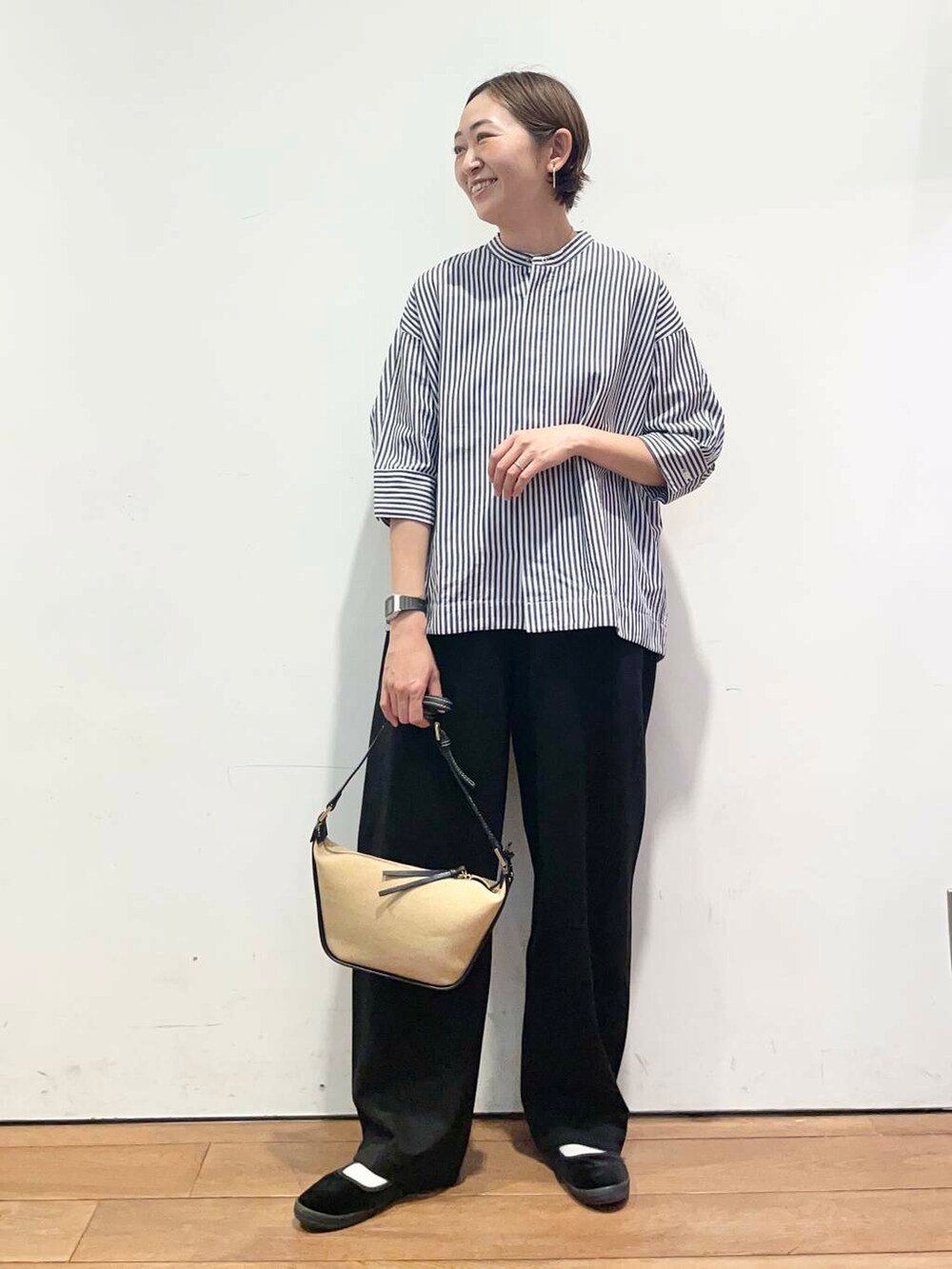 ブラック系のその他パンツ、ブルー系のシャツ/ブラウス、ブラック系のショルダーバッグを着用したレディースの春コーディネートの2枚目の写真