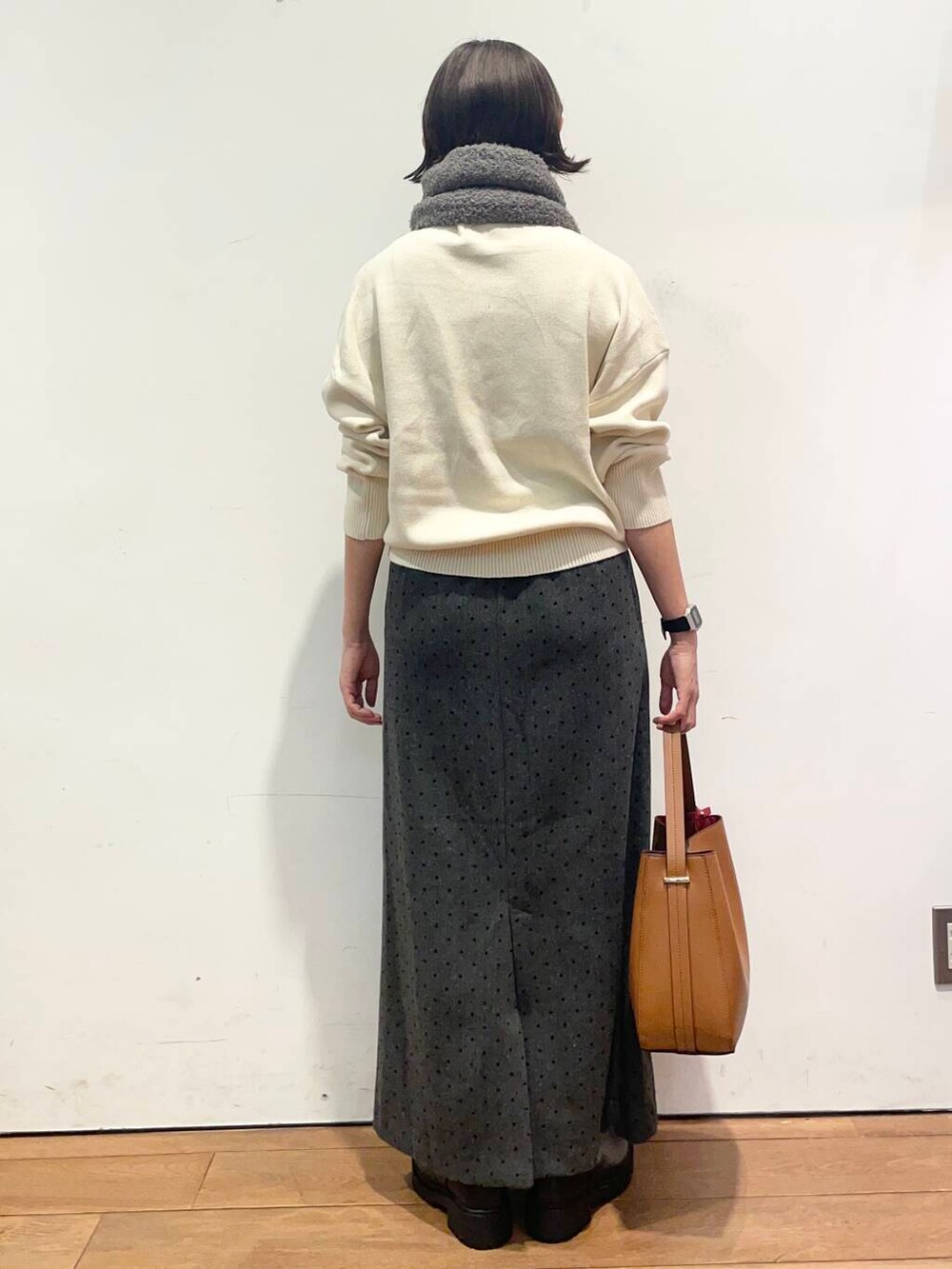 ブラウン系のハンドバッグ、ブラック系のブーツ、ホワイト系のニット/セーターを着用したレディースの秋コーディネートの5枚目の写真