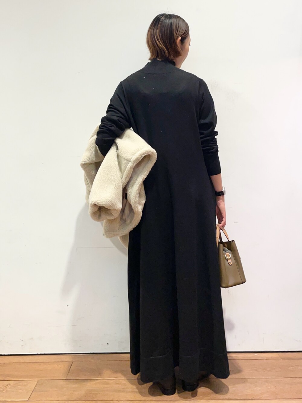 ホワイト系のその他アウター、ブラウン系のハンドバッグ、ブラック系のワンピースを着用したレディースの冬コーディネートの8枚目の写真