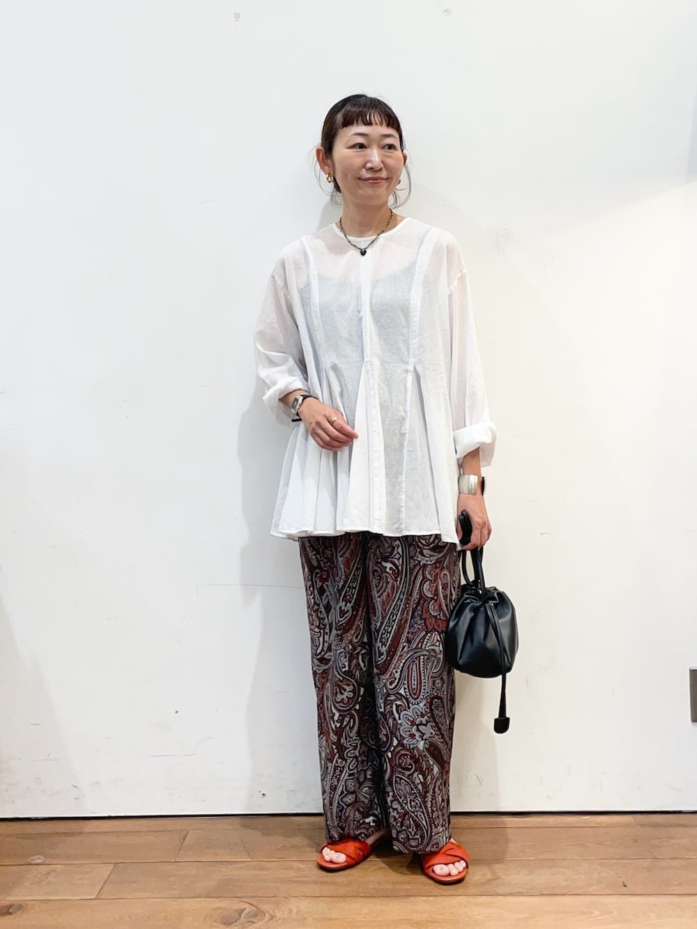 ホワイト系のシャツ/ブラウス、レッド系のその他パンツ、ブラック系のショルダーバッグを着用したレディースの夏コーディネートの2枚目の写真