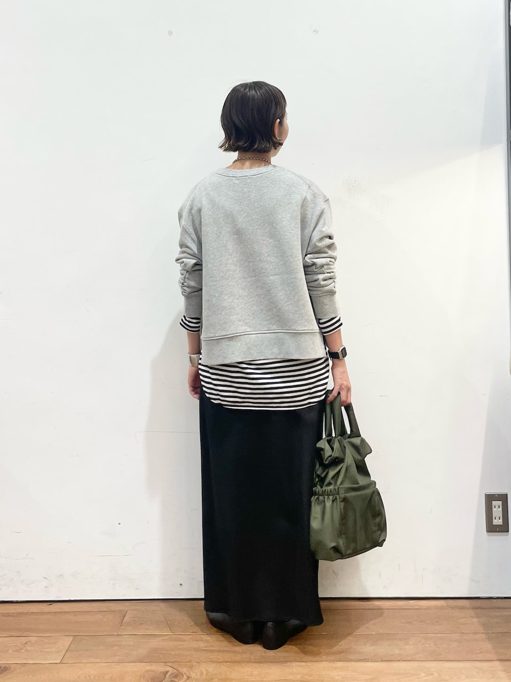 グレー系のスウェット、ホワイト系のTシャツ/カットソー、ブラック系のスリッポンを着用したレディースの秋コーディネートの5枚目の写真