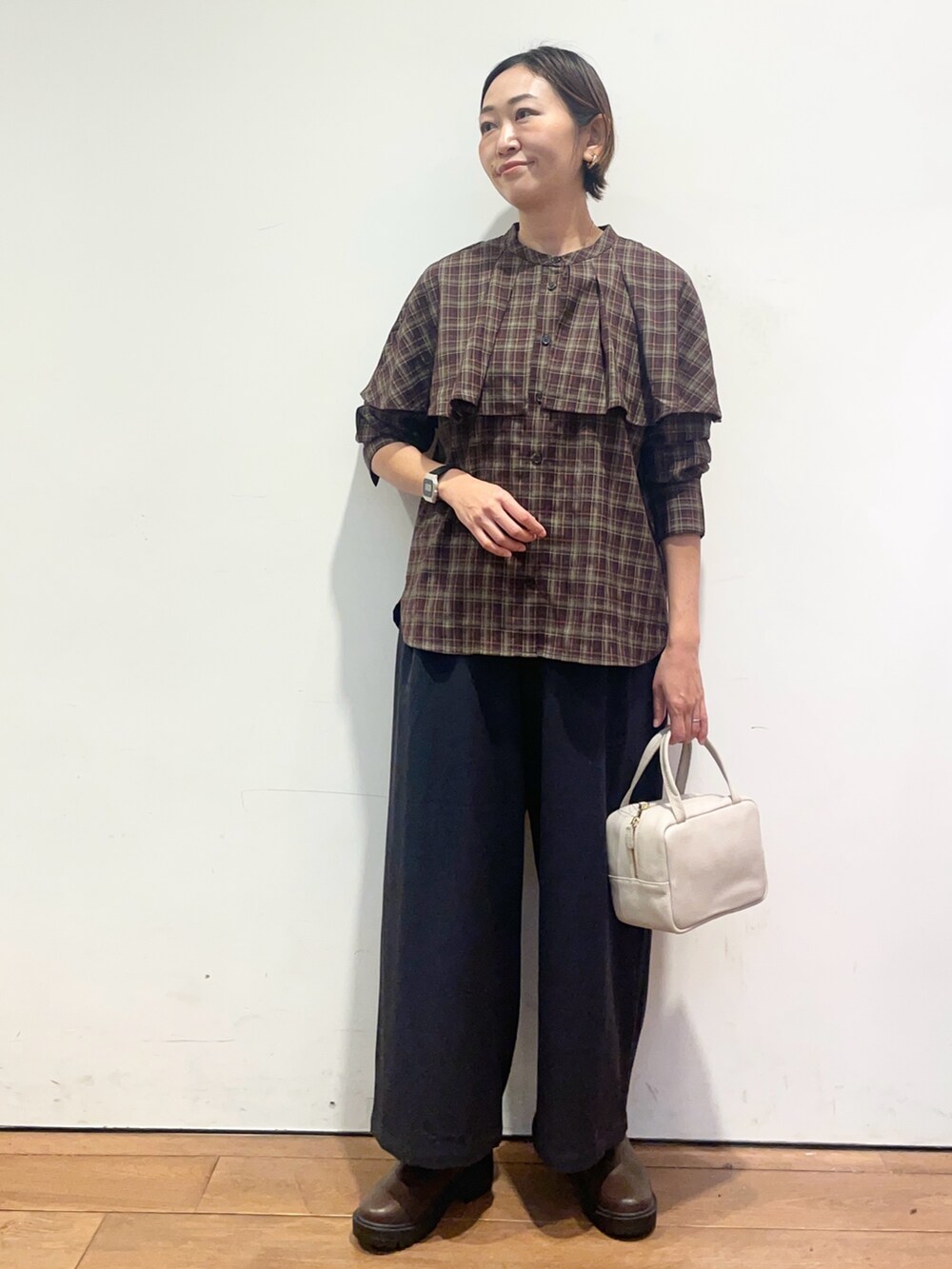 ブラウン系のブーツ、グレー系のボストンバッグ、ブルー系のその他パンツを着用したレディースの秋コーディネートの2枚目の写真