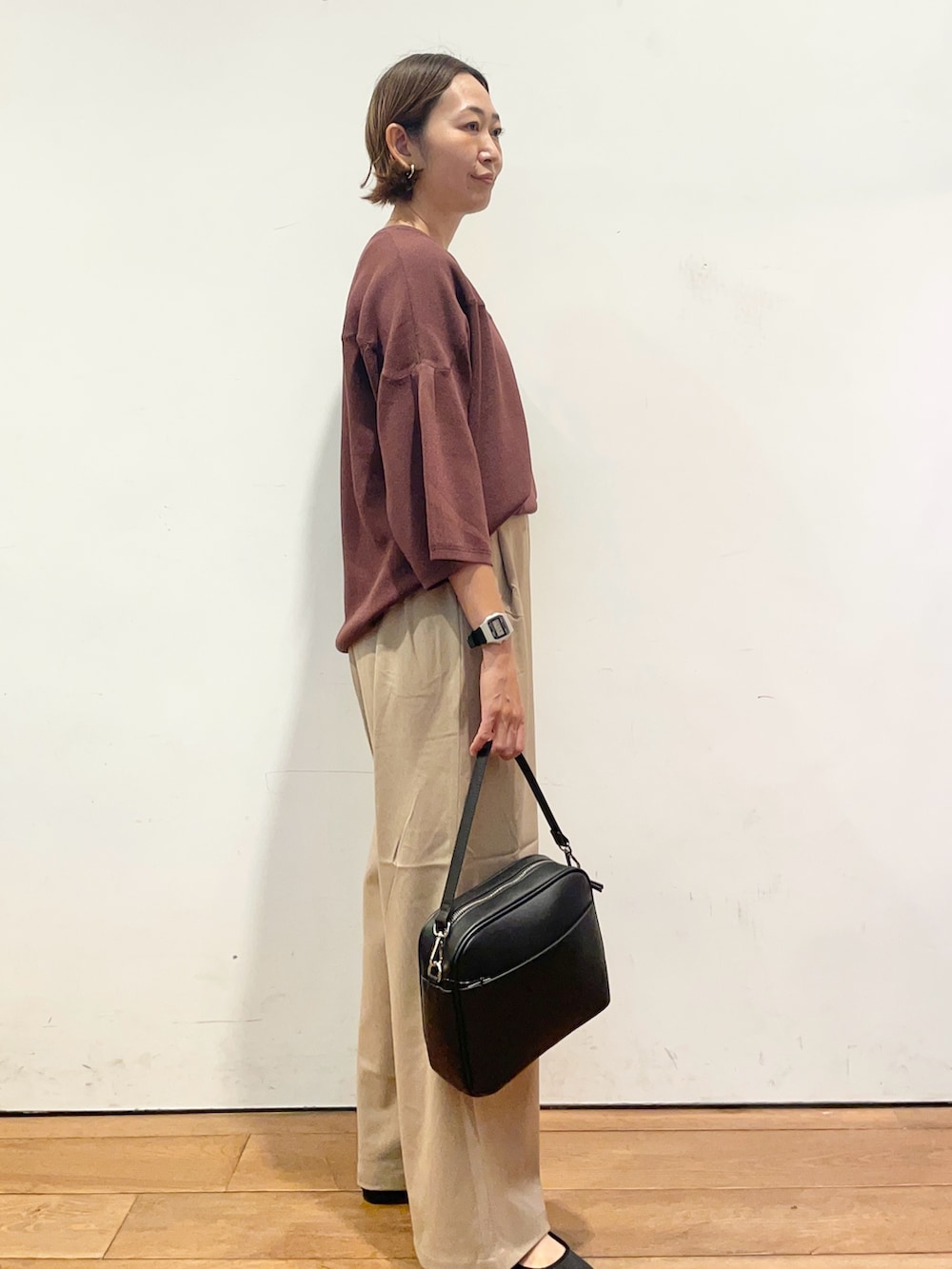 ベージュ系のその他パンツ、ブラウン系のニット/セーター、ブラック系のショルダーバッグを着用したレディースの秋コーディネートの4枚目の写真