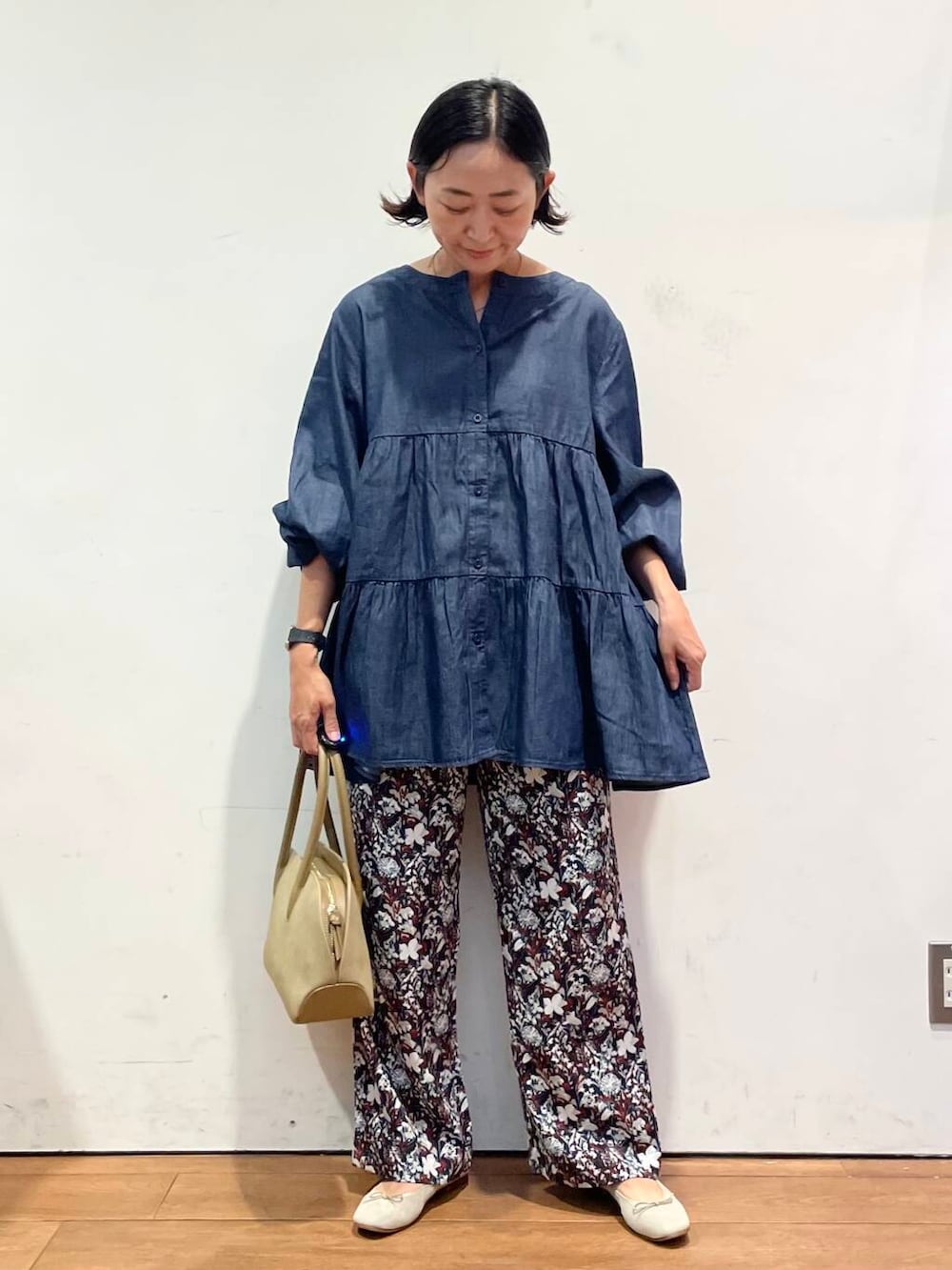 ブラウン系のバレエシューズ、レッド系のその他パンツ、ベージュ系のハンドバッグを着用したレディースの秋コーディネートの4枚目の写真