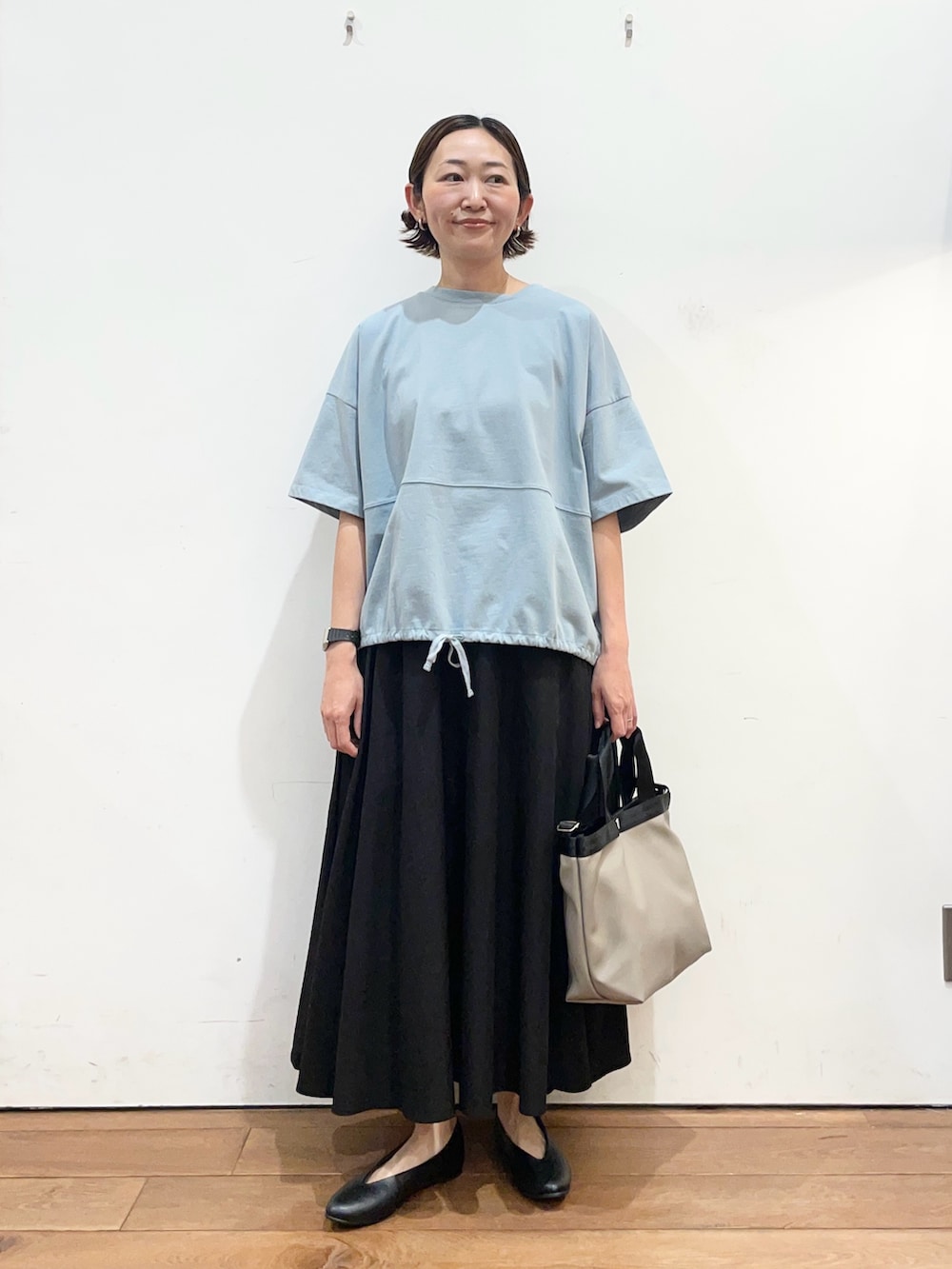 ブルー系のTシャツ/カットソー、ブラック系のパンプス、グレー系のハンドバッグを着用したレディースの春コーディネートの2枚目の写真