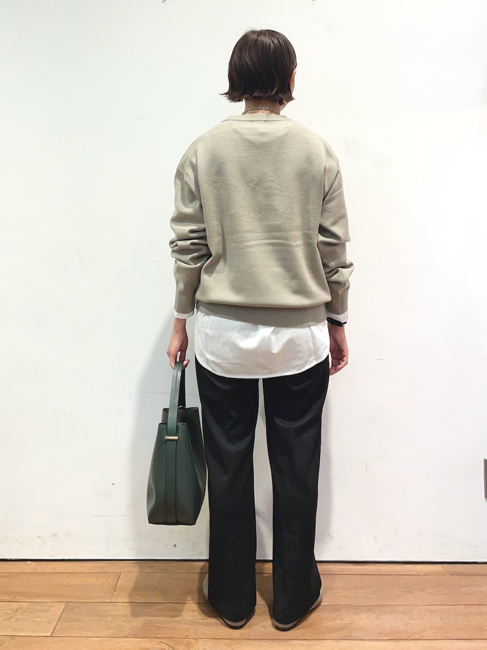 ベージュ系のニット/セーター、ホワイト系のTシャツ/カットソー、グリーン系のハンドバッグを着用したレディースの秋コーディネートの4枚目の写真