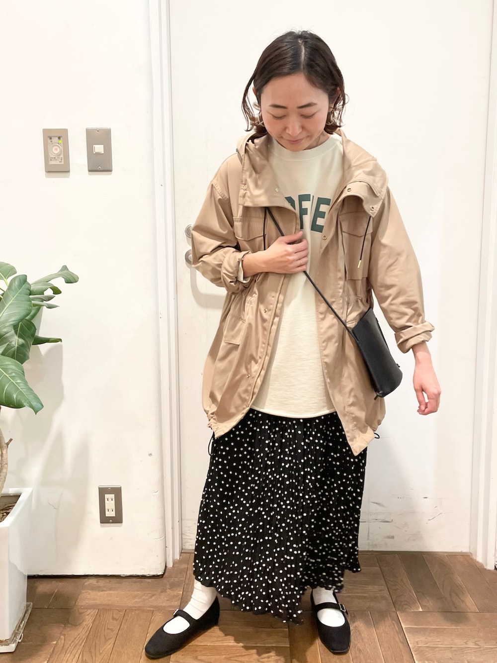 ブラック系のショルダーバッグ、ベージュ系のスウェット、ベージュ系のミリタリージャケットを着用したレディースの冬コーディネートの2枚目の写真