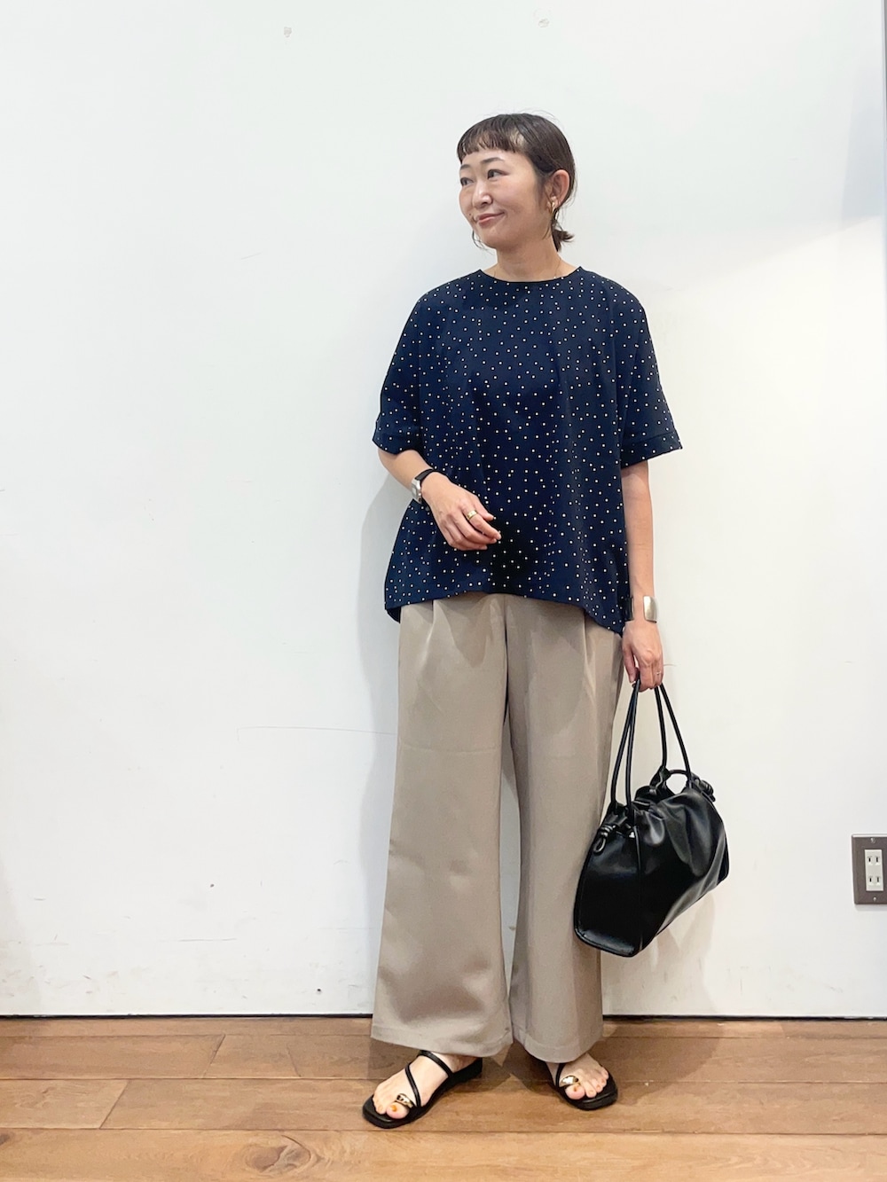 ブルー系のTシャツ/カットソー、ベージュ系のその他パンツ、ブラック系のトートバッグを着用したレディースの夏コーディネートの2枚目の写真