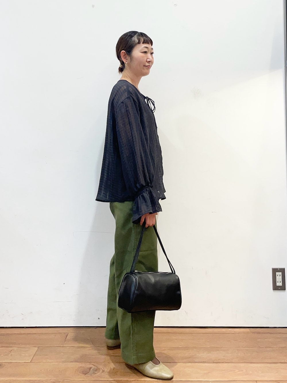 ブラック系のシャツ/ブラウス、グリーン系のその他パンツ、ブラック系のハンドバッグを着用したレディースの秋コーディネートの4枚目の写真