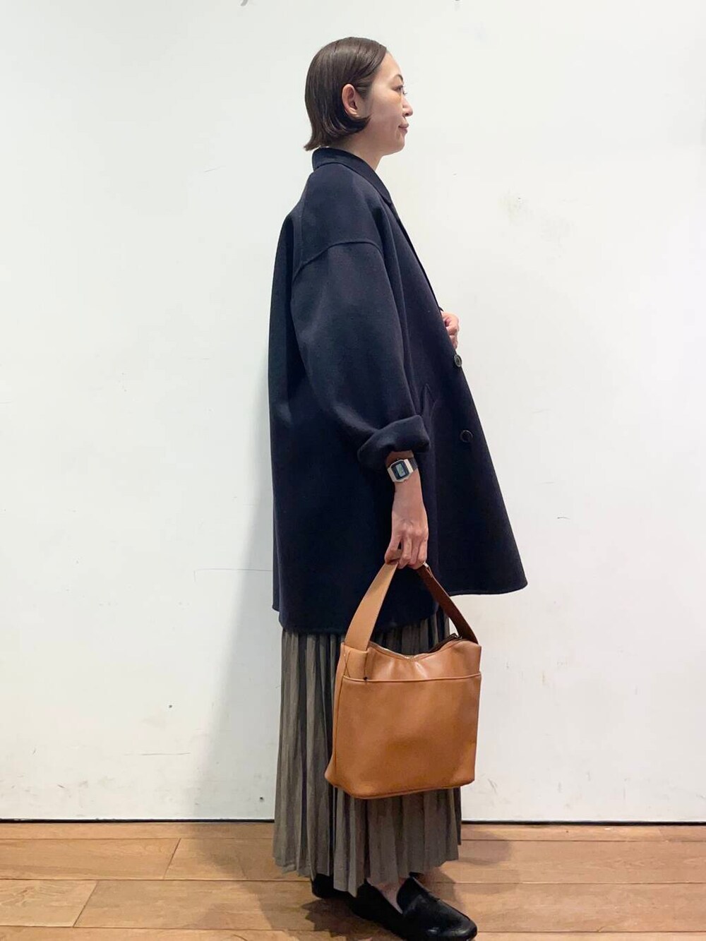 ブルー系のその他アウター、イエロー系のショルダーバッグ、ベージュ系のスカートを着用したレディースの秋コーディネートの3枚目の写真