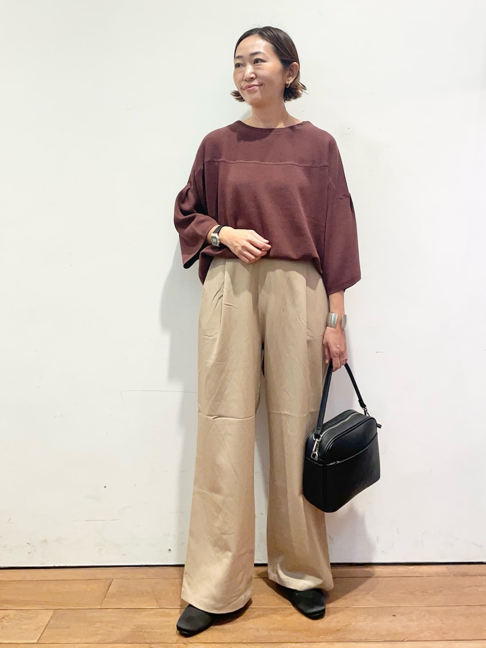 ベージュ系のその他パンツ、ブラウン系のニット/セーター、ブラック系のショルダーバッグを着用したレディースの秋コーディネートの2枚目の写真