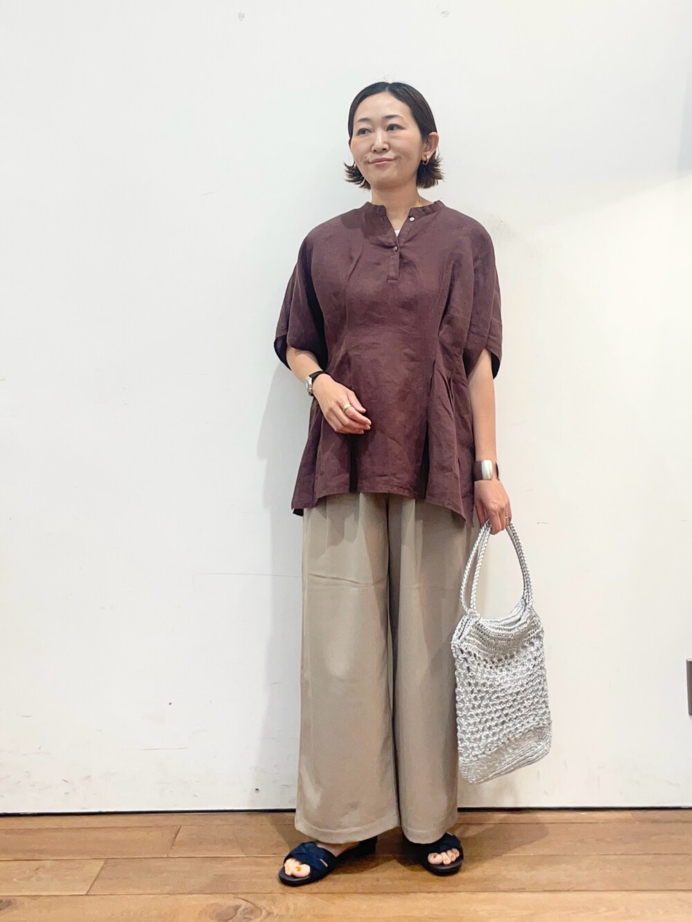 レッド系のシャツ/ブラウス、ベージュ系のその他パンツ、ブルー系のサンダルを着用したレディースの春コーディネートの2枚目の写真