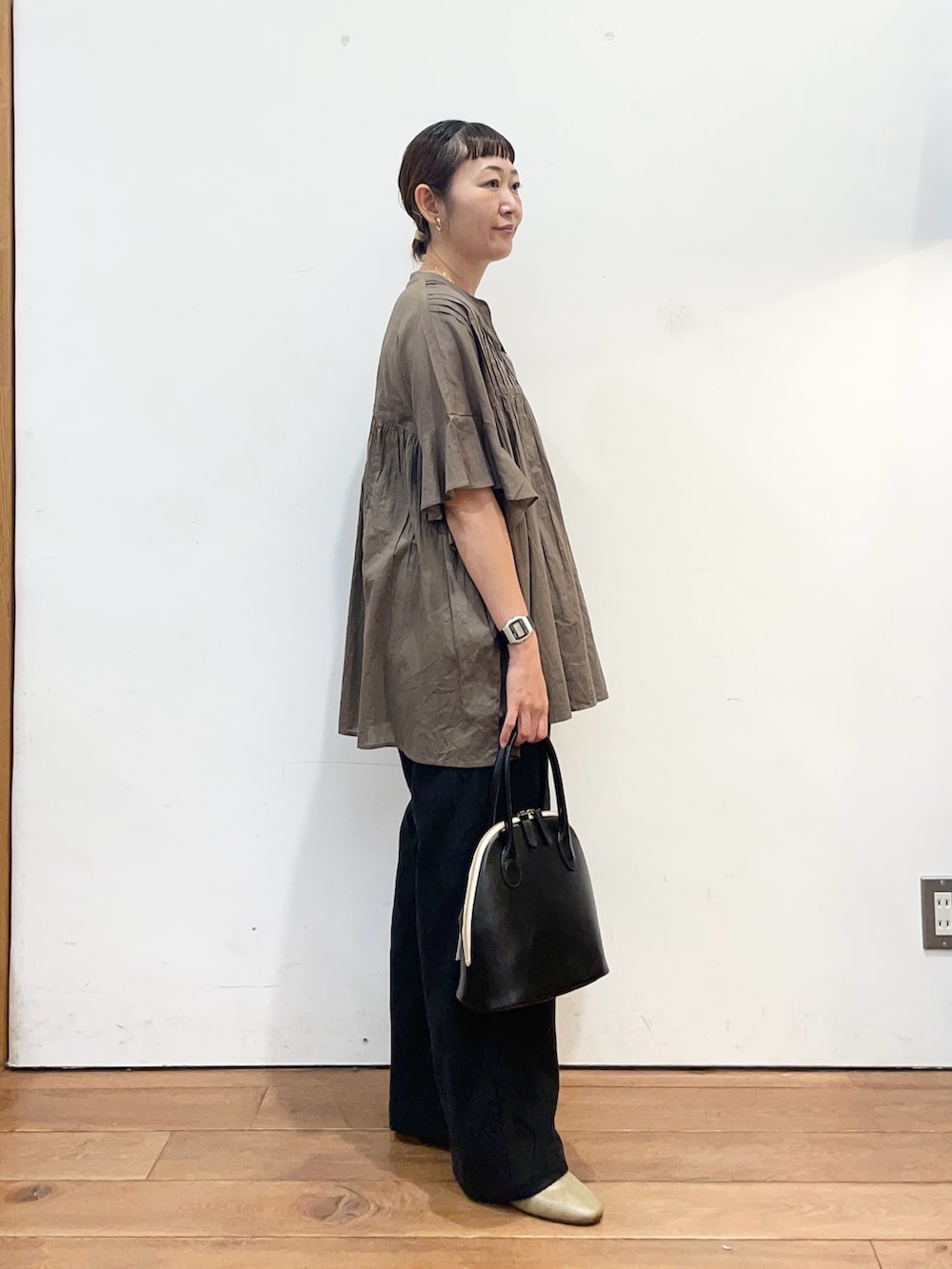 グリーン系のシャツ/ブラウス、ブラック系のその他パンツ、ブラック系のハンドバッグを着用したレディースの秋コーディネートの3枚目の写真