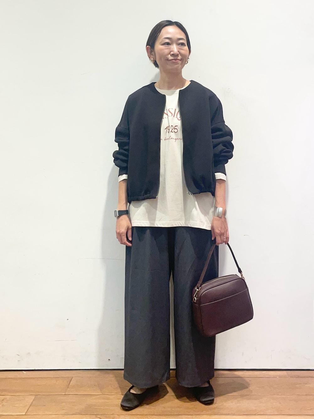 ベージュ系のTシャツ/カットソー、ブラック系のカーディガン/ボレロ、グレー系のその他パンツを着用したレディースの秋コーディネートの2枚目の写真