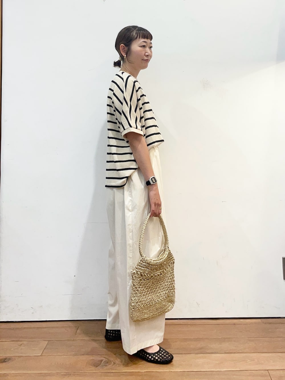 ホワイト系のTシャツ/カットソー、ホワイト系のその他パンツ、ゴールド系のトートバッグを着用したレディースの夏コーディネートの4枚目の写真