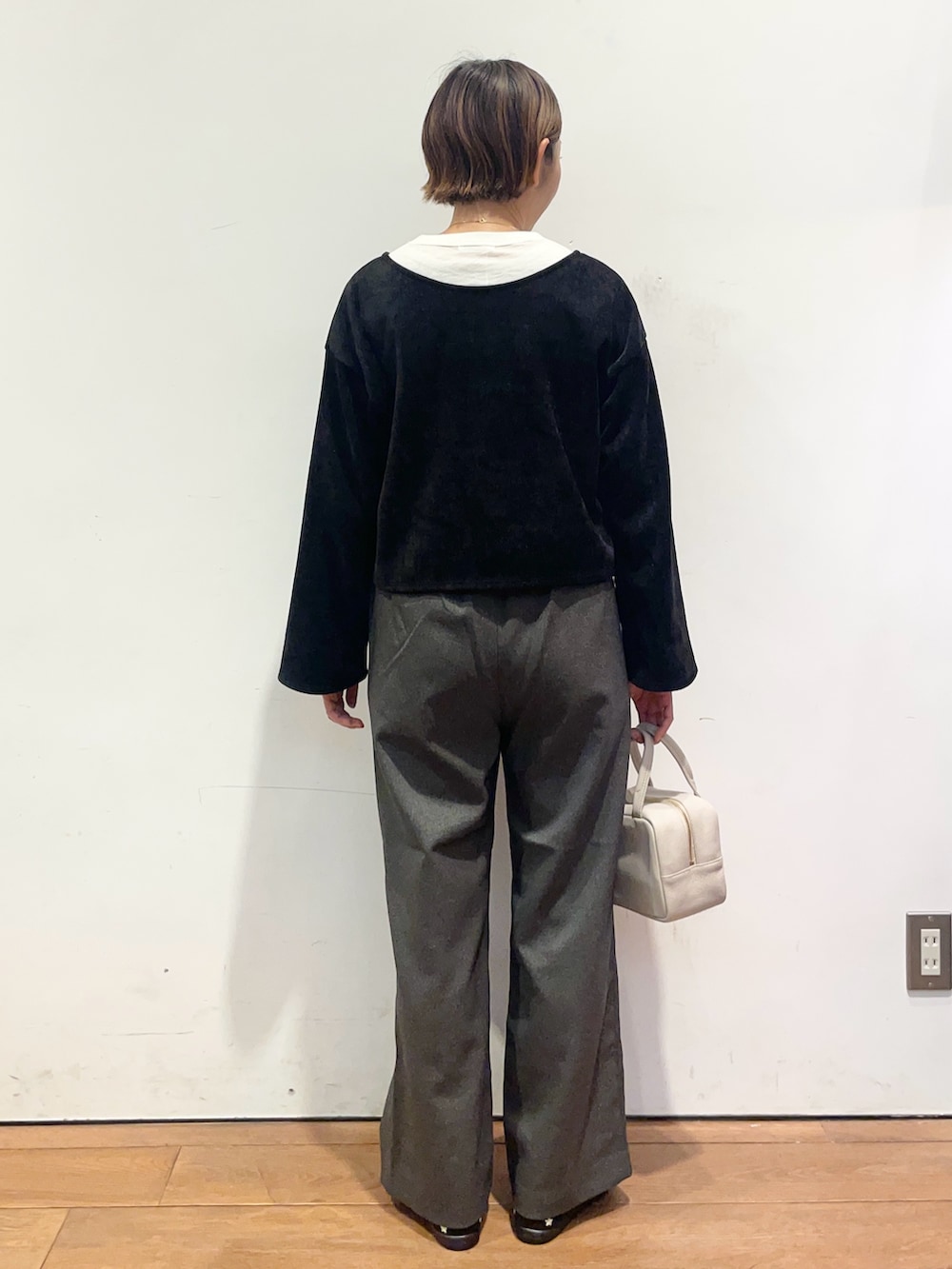 ホワイト系のTシャツ/カットソー、ブラック系のスニーカー、グレー系のボストンバッグを着用したレディースの秋コーディネートの5枚目の写真