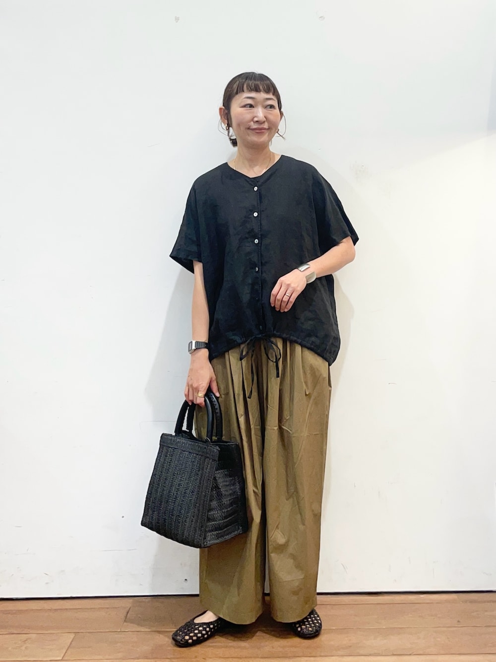 ブラック系のシャツ/ブラウス、ベージュ系のその他パンツ、ブラック系のサンダルを着用したレディースの夏コーディネートの2枚目の写真