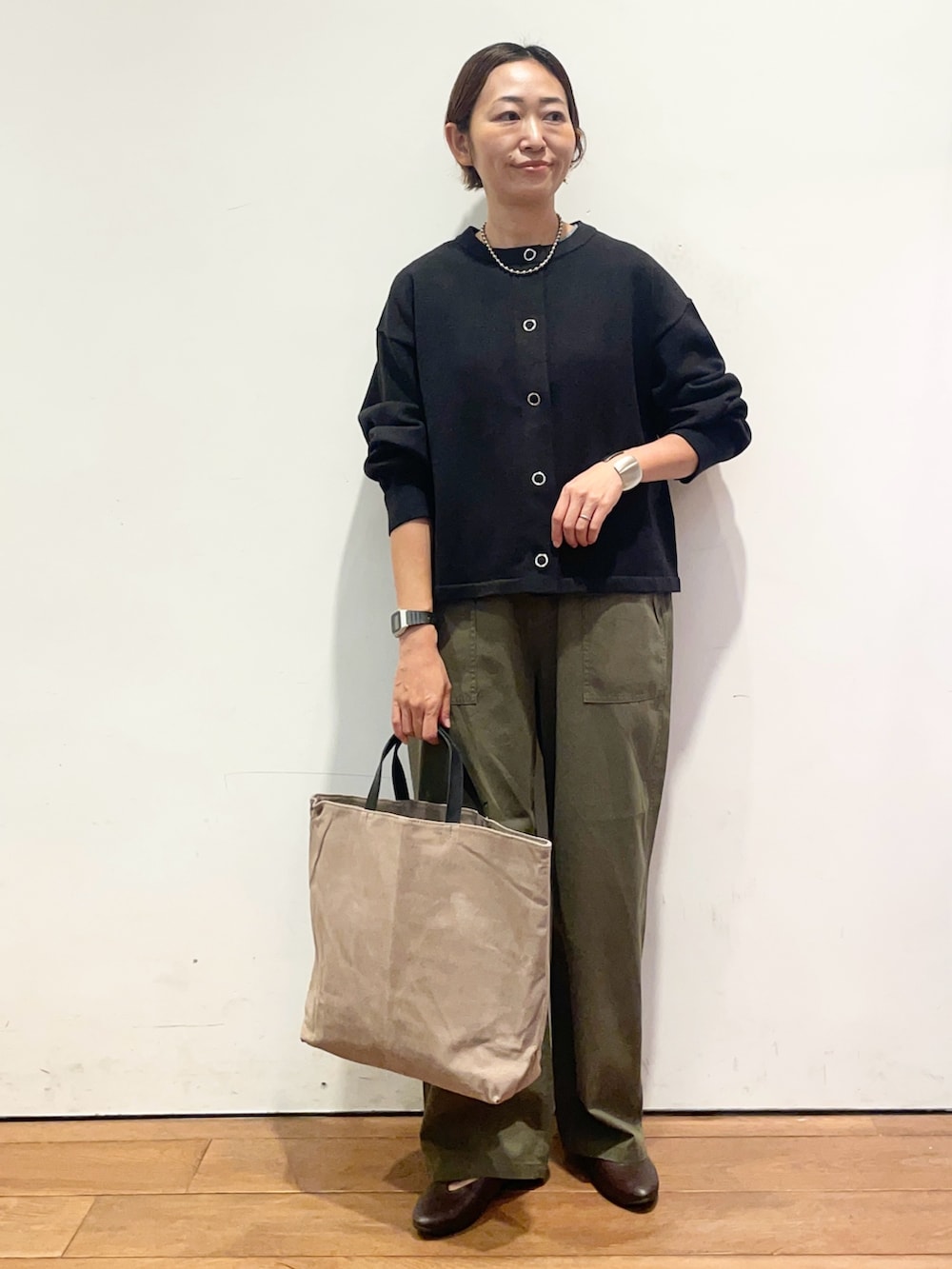 ブラック系のカーディガン/ボレロ、ブラウン系のパンプス、グレー系のバッグを着用したレディースの秋コーディネートの2枚目の写真