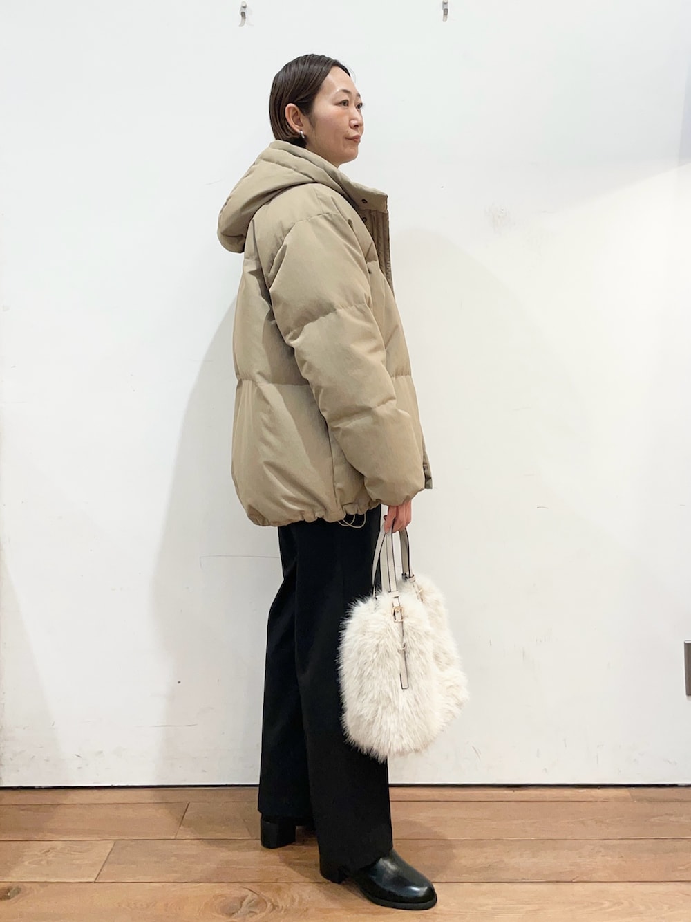 ブラウン系のダウンジャケット/コート、グレー系のニット/セーター、ブラック系のブーツを着用したレディースの冬コーディネートの3枚目の写真