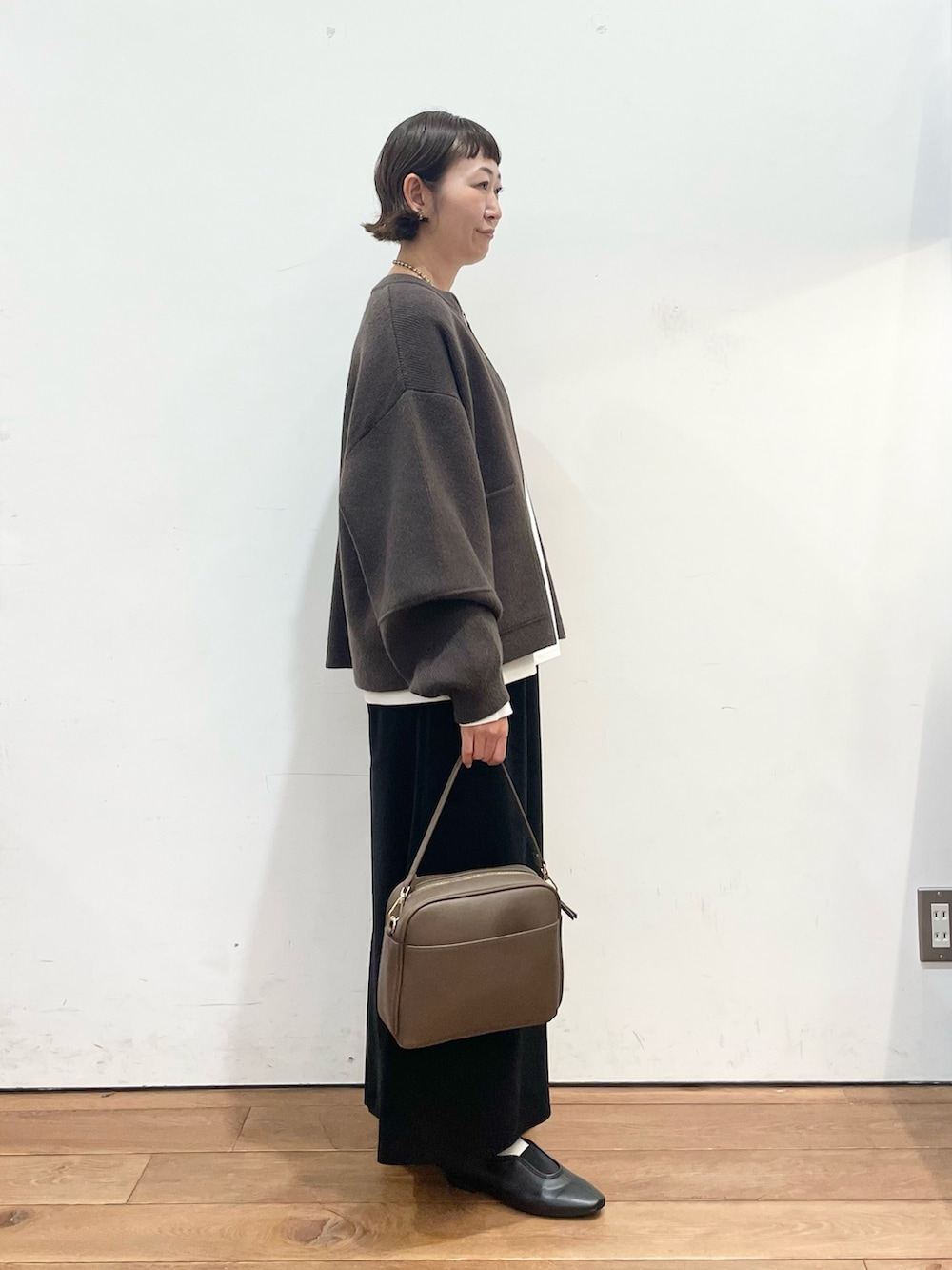 ブラウン系のブルゾン、ホワイト系のTシャツ/カットソー、ブラウン系のショルダーバッグを着用したレディースの秋コーディネートの4枚目の写真