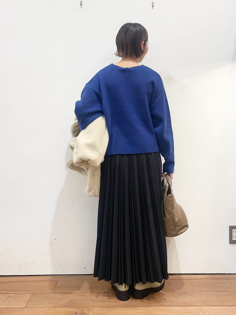 ホワイト系のその他アウター、ブルー系のニット/セーター、ブラック系のスカートを着用したレディースの冬コーディネートの8枚目の写真
