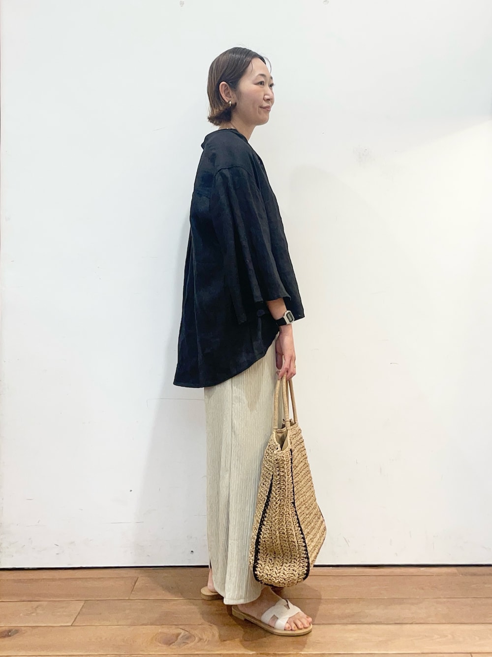 ブラック系のシャツ/ブラウス、ベージュ系のスカート、ベージュ系のトートバッグを着用したレディースの春コーディネートの3枚目の写真
