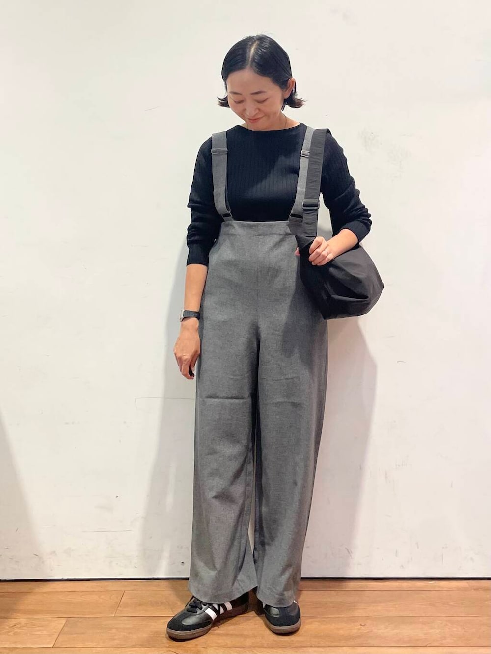 ブラック系のショルダーバッグ、グレー系のサロペット/オーバーオール、ブラック系のスニーカーを着用したレディースの秋コーディネートの4枚目の写真