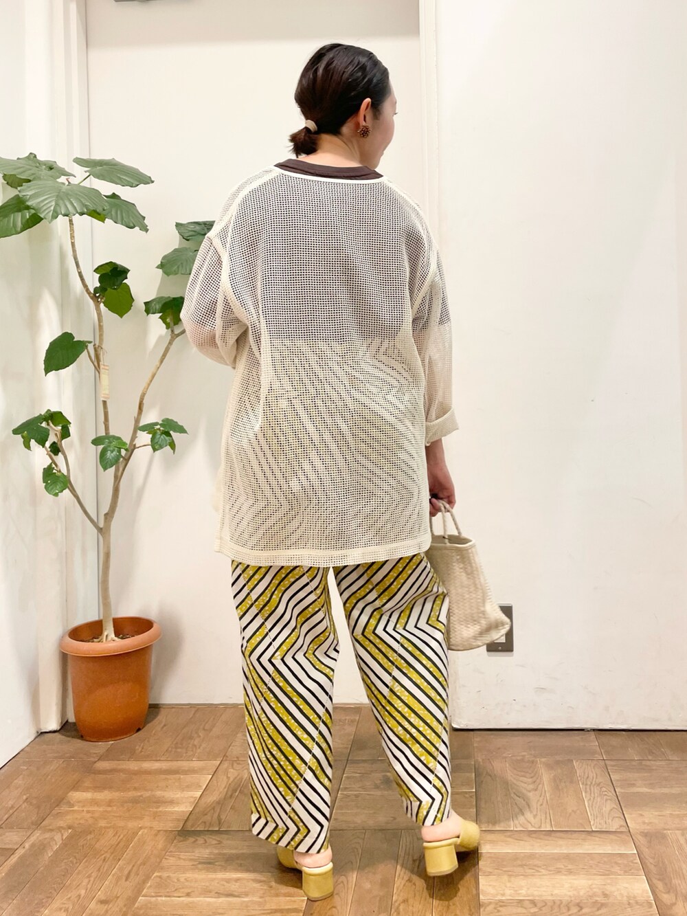 ブラウン系のTシャツ/カットソー、ベージュ系のカーディガン/ボレロ、ホワイト系のハンドバッグを着用したレディースの春コーディネートの3枚目の写真