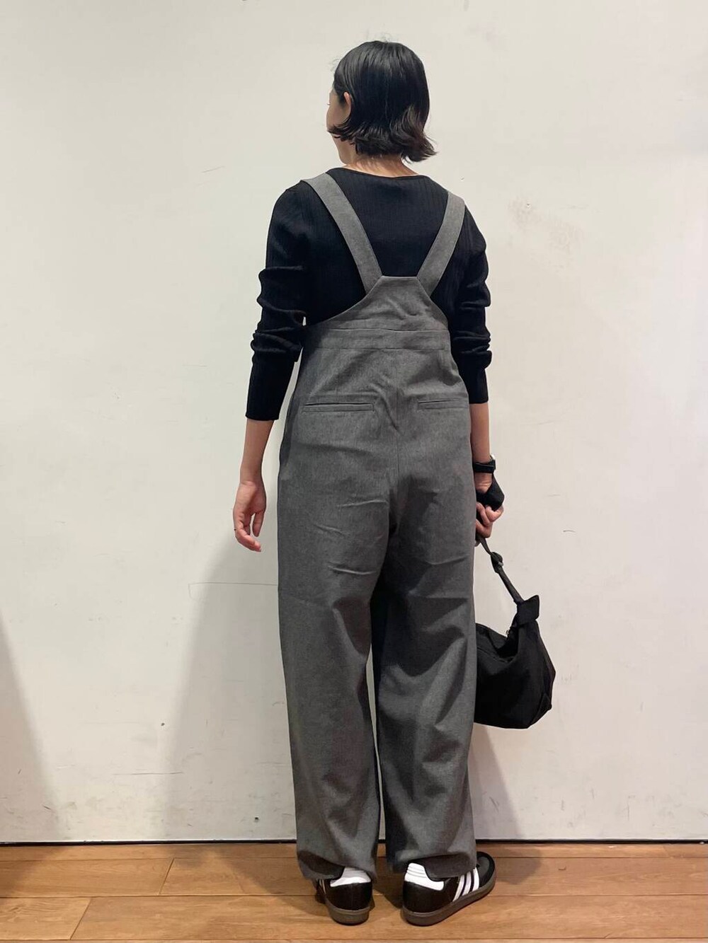 ブラック系のショルダーバッグ、グレー系のサロペット/オーバーオール、ブラック系のスニーカーを着用したレディースの秋コーディネートの7枚目の写真