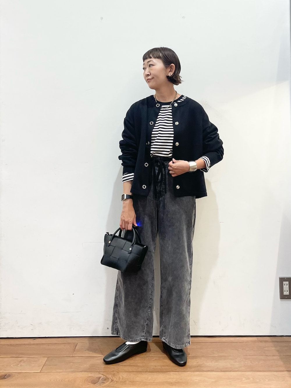 ブラック系のカーディガン/ボレロ、ホワイト系のTシャツ/カットソー、ブラック系のスリッポンを着用したレディースの秋コーディネートの3枚目の写真