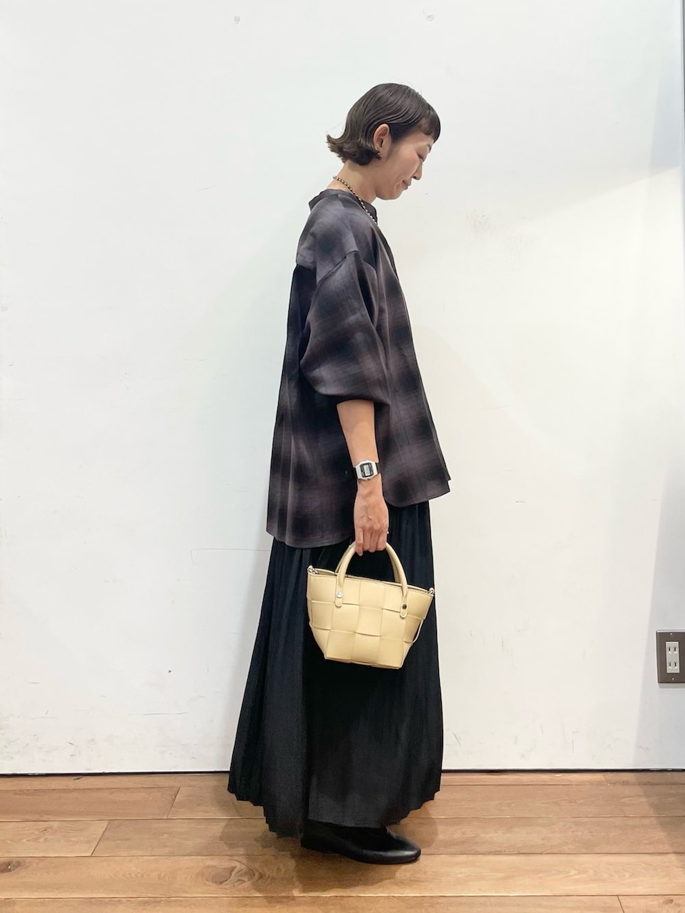 ベージュ系のハンドバッグ、グレー系のシャツ/ブラウス、ブラック系のスカートを着用したレディースの秋コーディネートの4枚目の写真