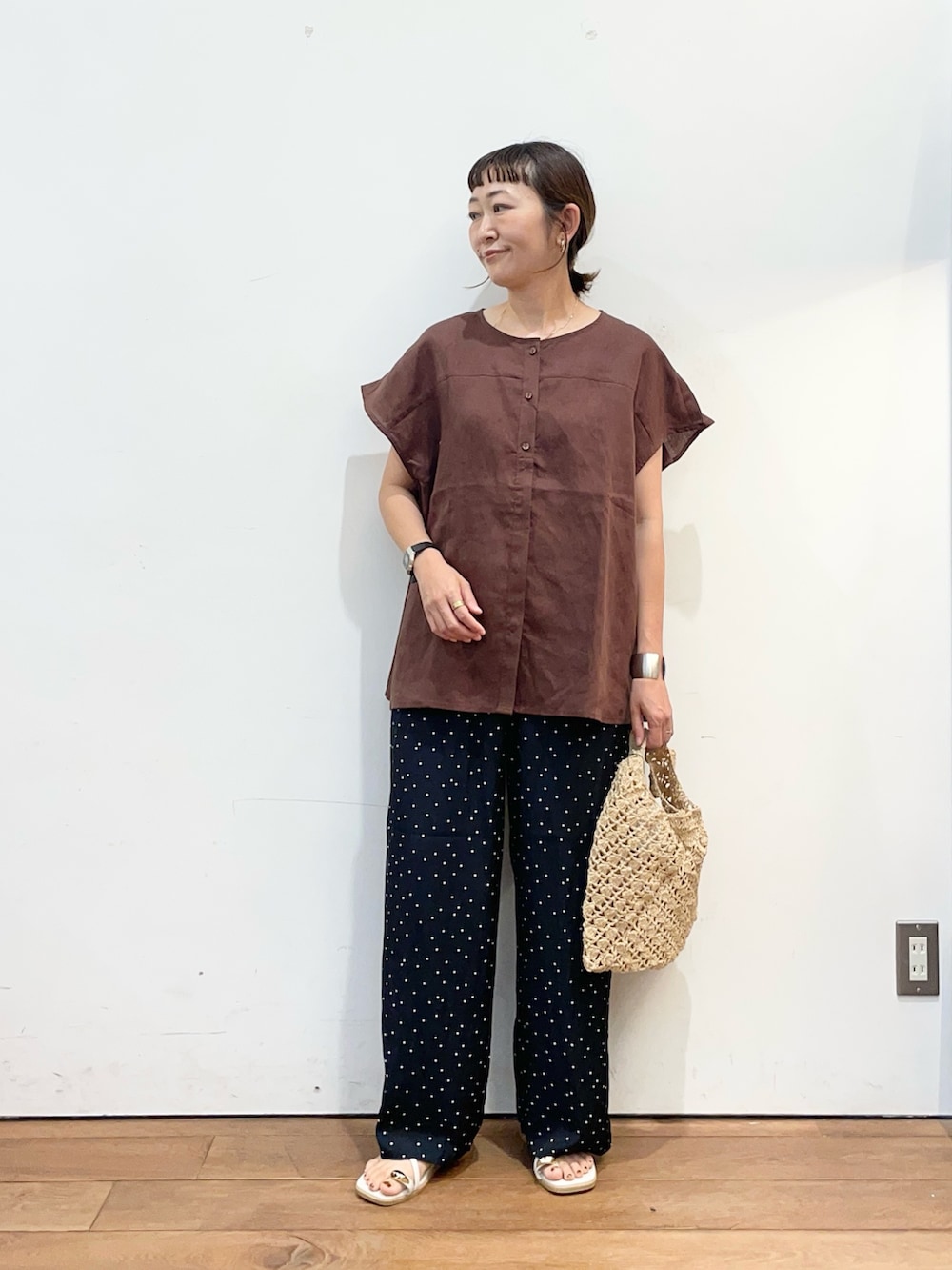 ブラウン系のシャツ/ブラウス、ブルー系のその他パンツ、ベージュ系のハンドバッグを着用したレディースの夏コーディネートの2枚目の写真