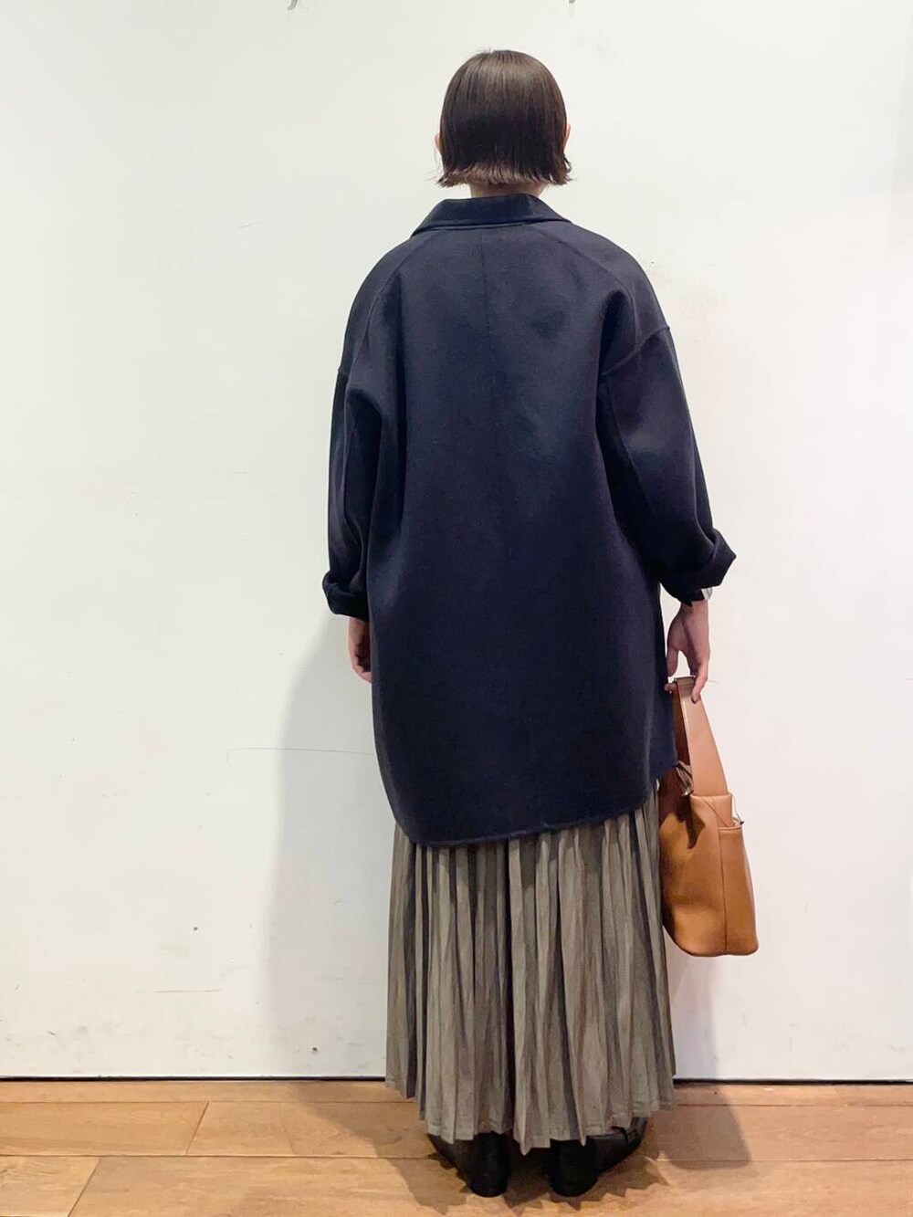 ブルー系のその他アウター、イエロー系のショルダーバッグ、ベージュ系のスカートを着用したレディースの秋コーディネートの4枚目の写真