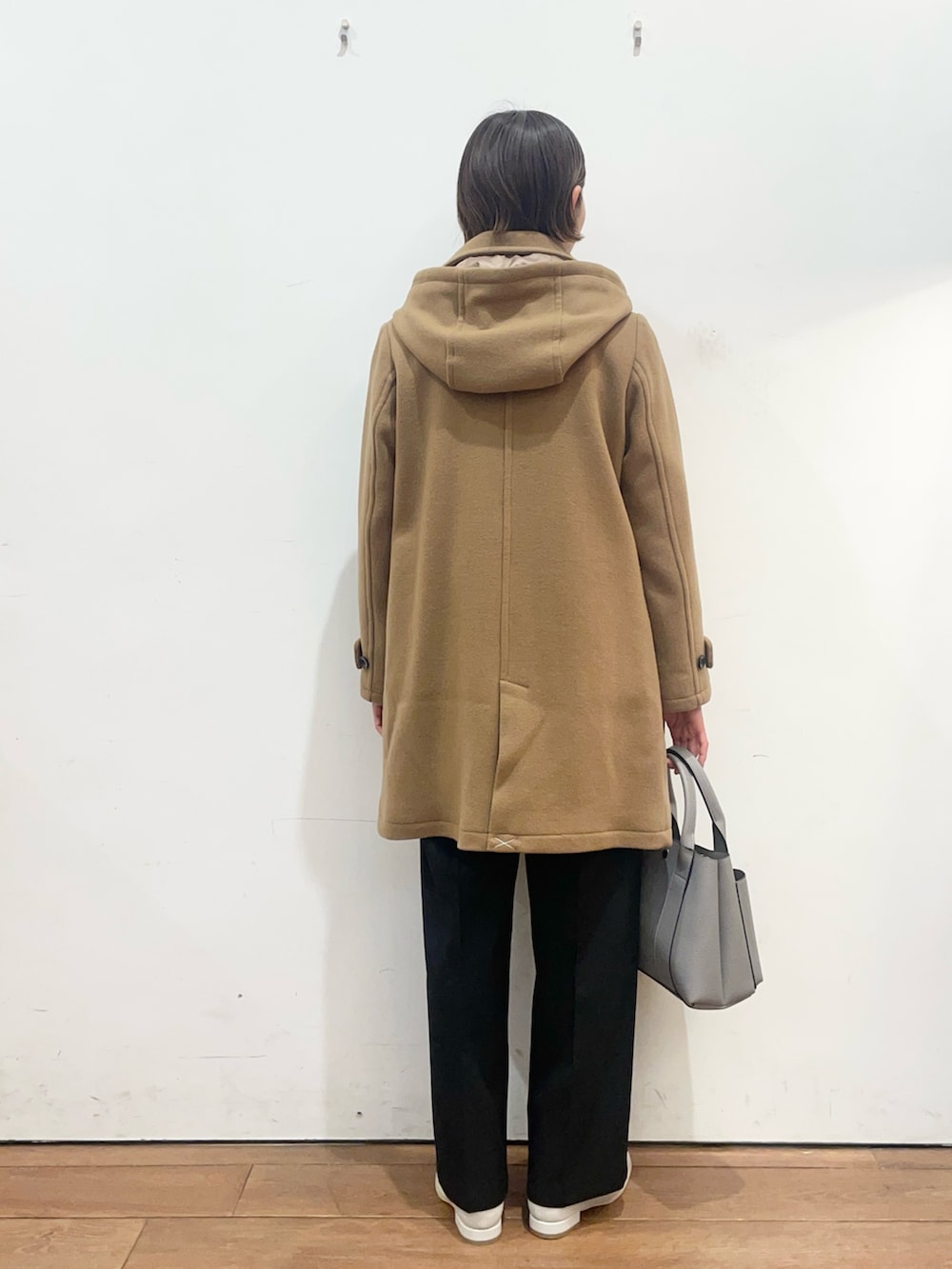 グレー系のトートバッグ、ホワイト系のブーツ、イエロー系のその他アウターを着用したレディースの冬コーディネートの4枚目の写真