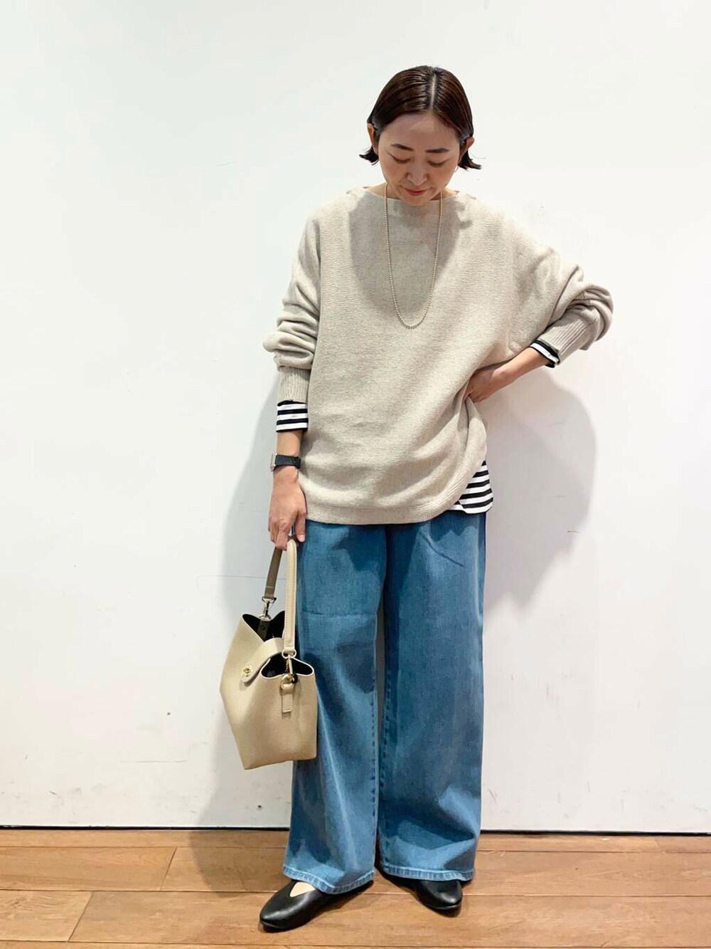 ブラック系のパンプス、ベージュ系のニット/セーター、ベージュ系のショルダーバッグを着用したレディースの秋コーディネートの3枚目の写真